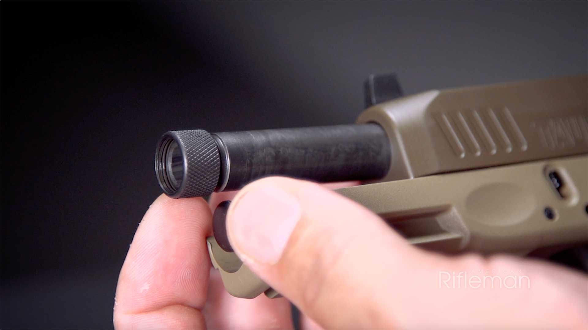Man unscrewing the thread protector on the Taurus G3 Tactical's threaded muzzle.