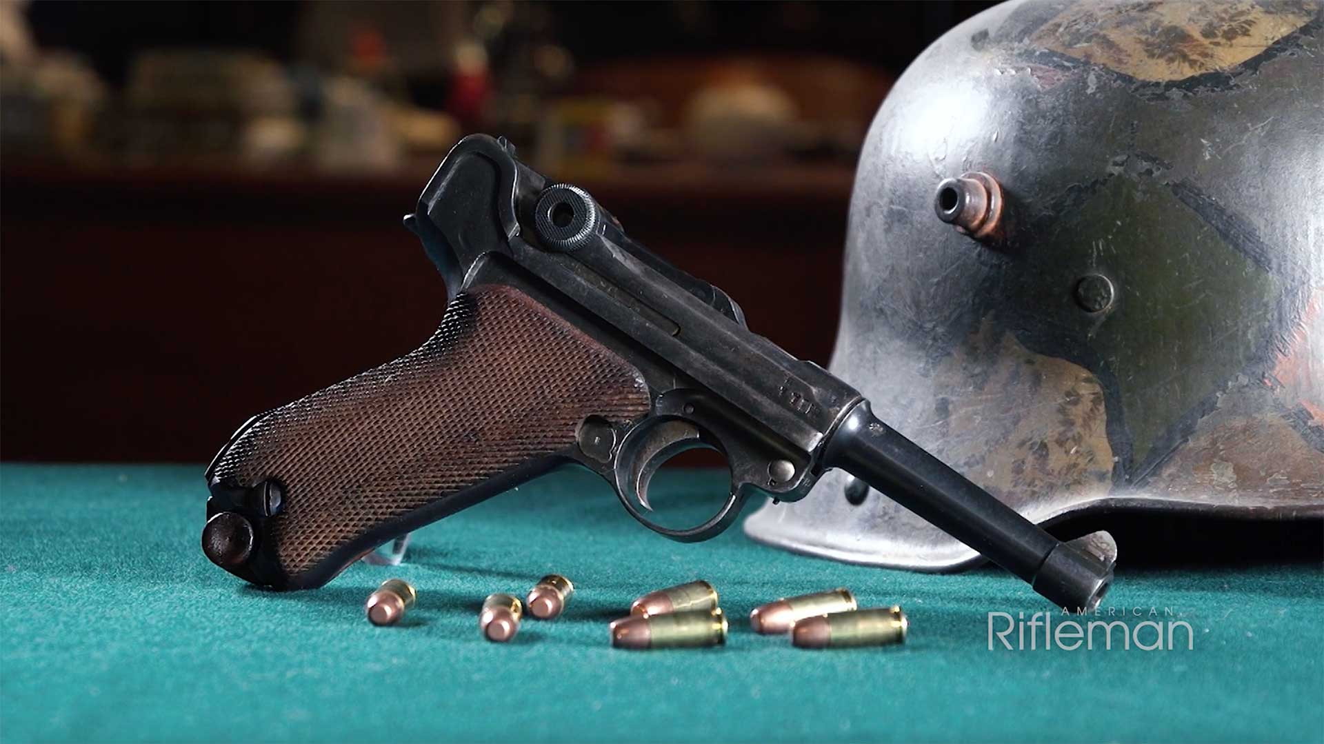 Right side of the P08 Luger pistol with a German steel helmet behind it.