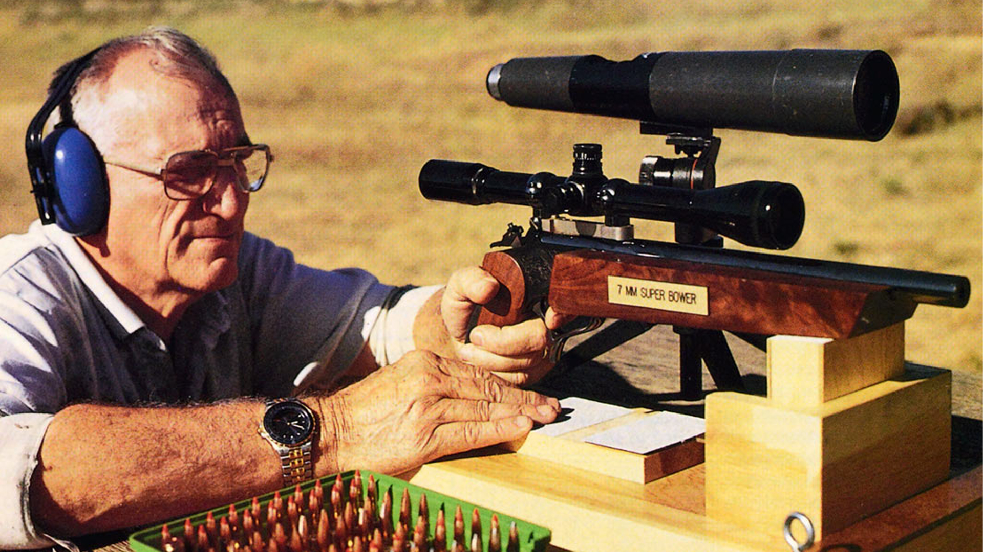 Don Bower at shooting bench outdoors with T/C Contender pistol and 7 mm Super Bower ammunition