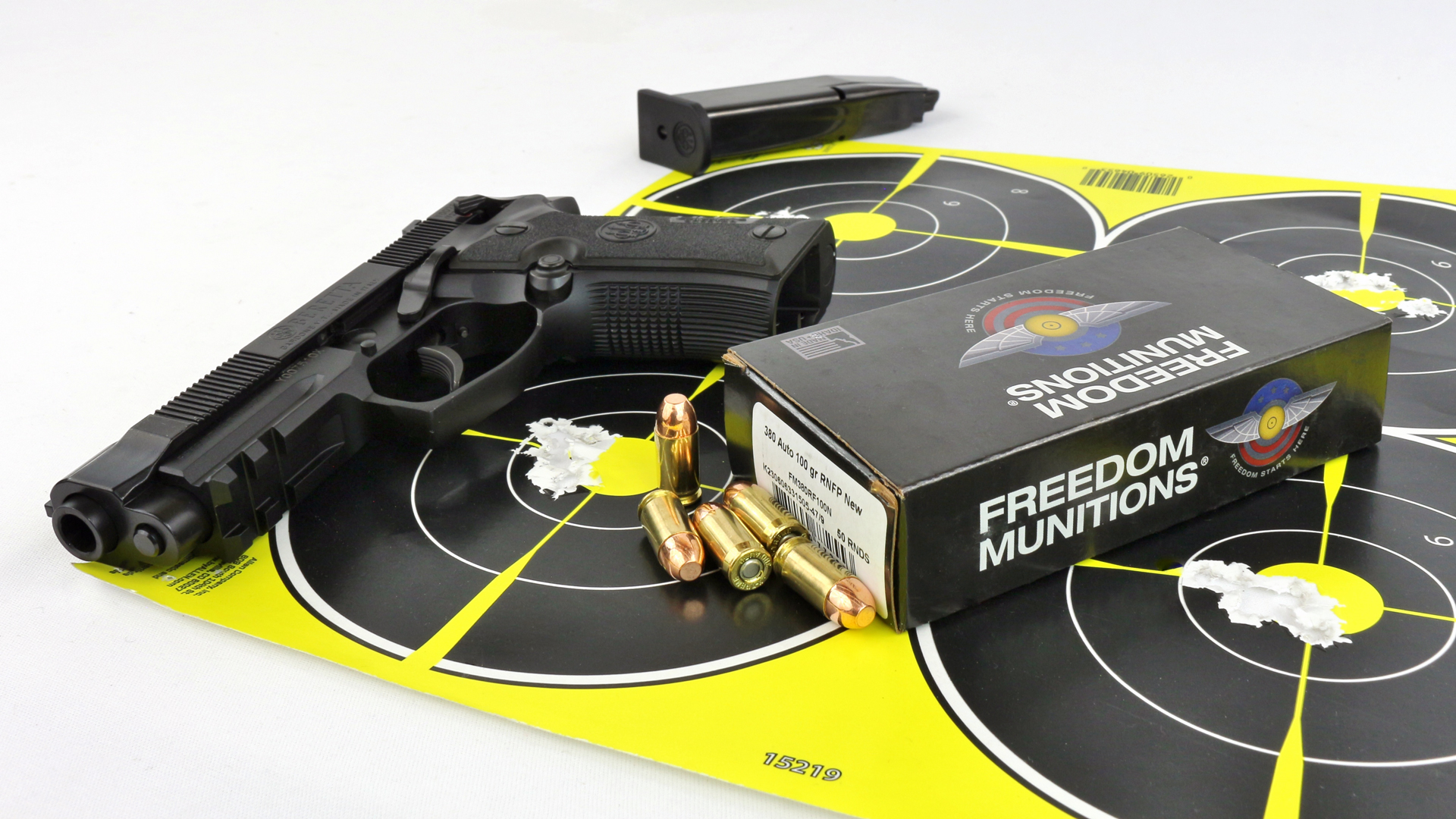 Beretta 80X Cheetah .380 ACP pistol shown on bullseye targets with magazine and ammunition Freedom Munitions black gun pistol brass cartridges
