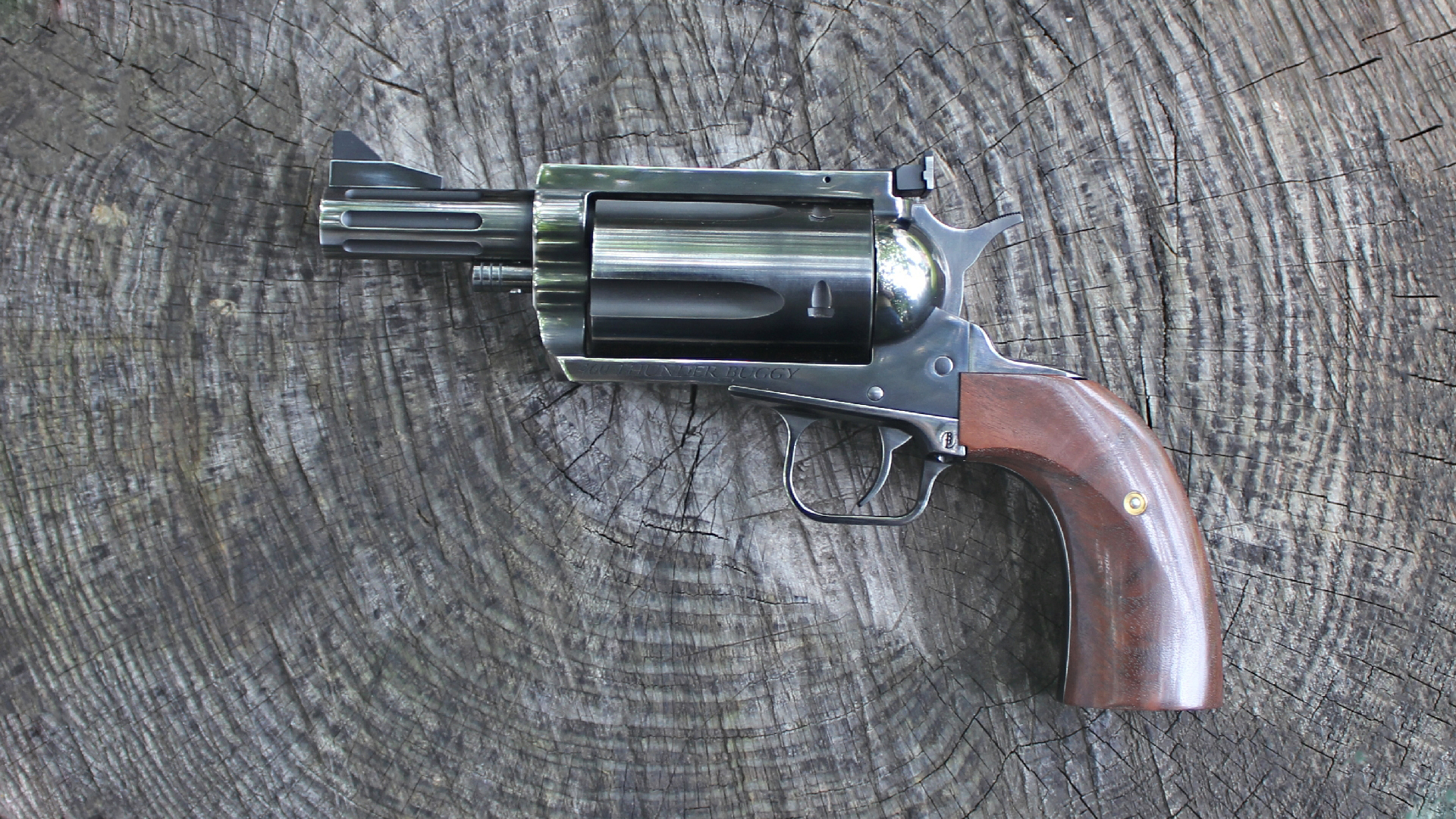 Magnum Research BFR Thunder Buggy revolver left-side view distressed Nitride finish walnut stocks log background