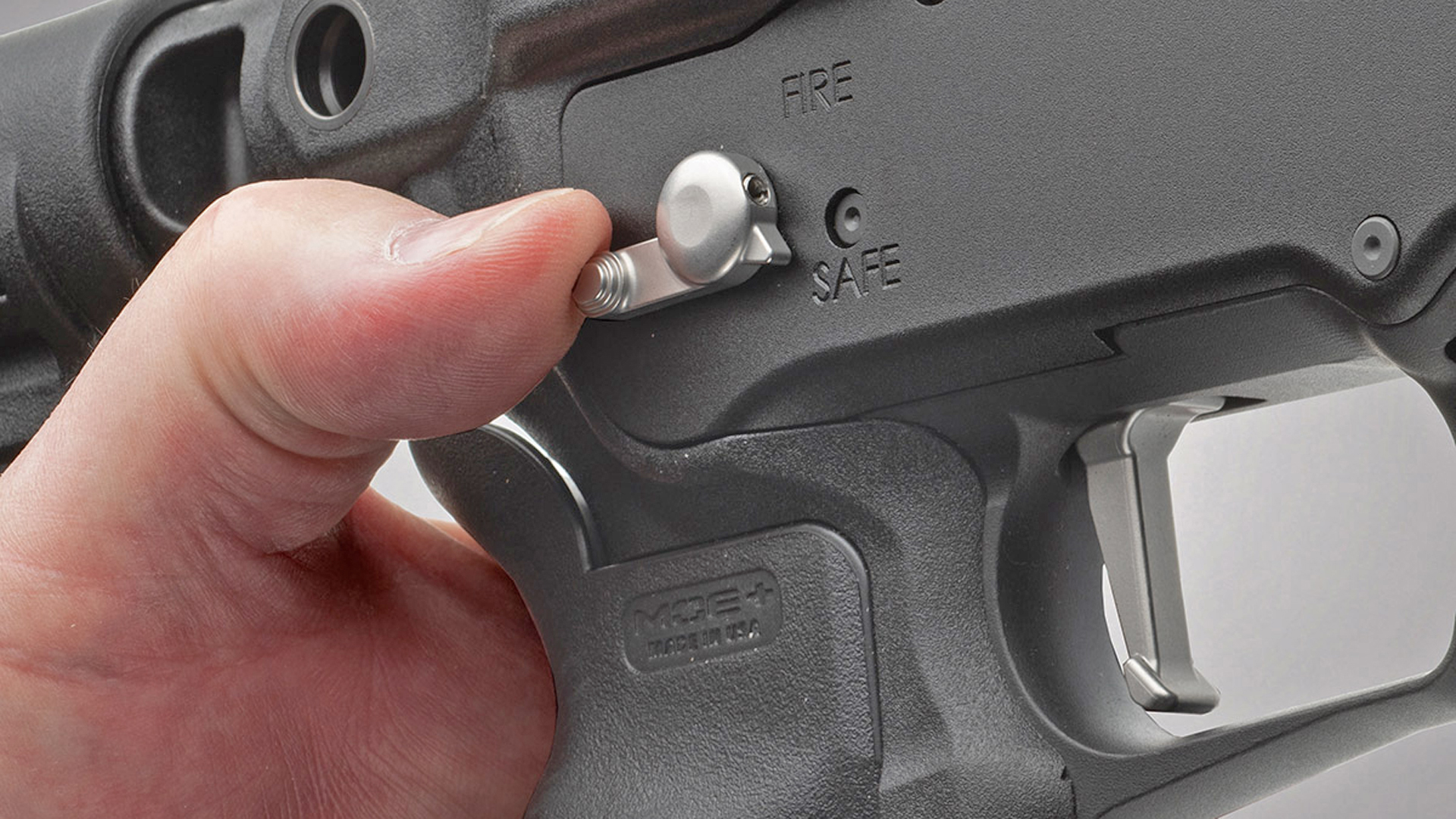 Mossberg 590R rotary safety lever actuated by thumb shown in safe position