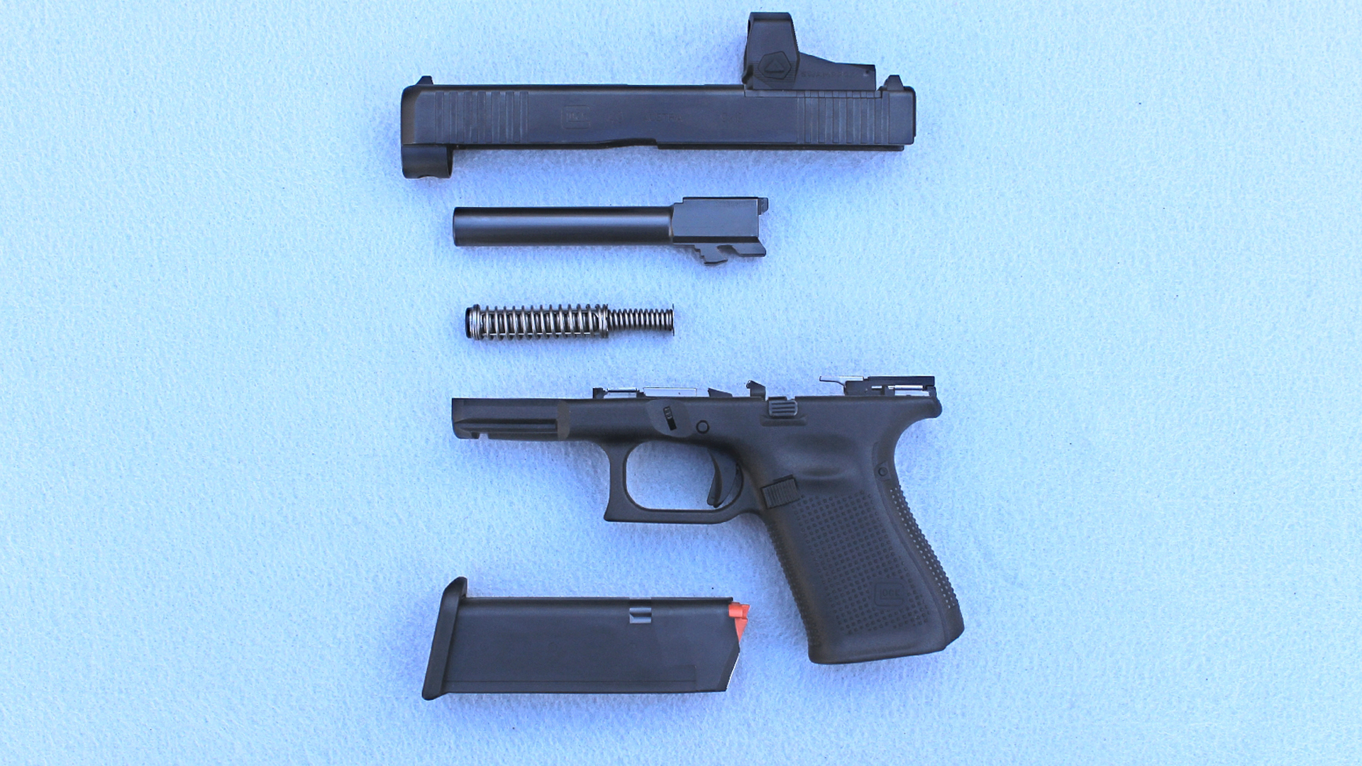 Glock G49 Gen5 MOS left-side view parts arranged exploded view optic slide barrel recoil spring assembly frame magazines