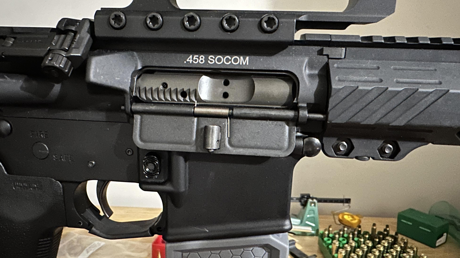 AR-15 receiver right-side view .458 SOCOM stamp loading bench tools background