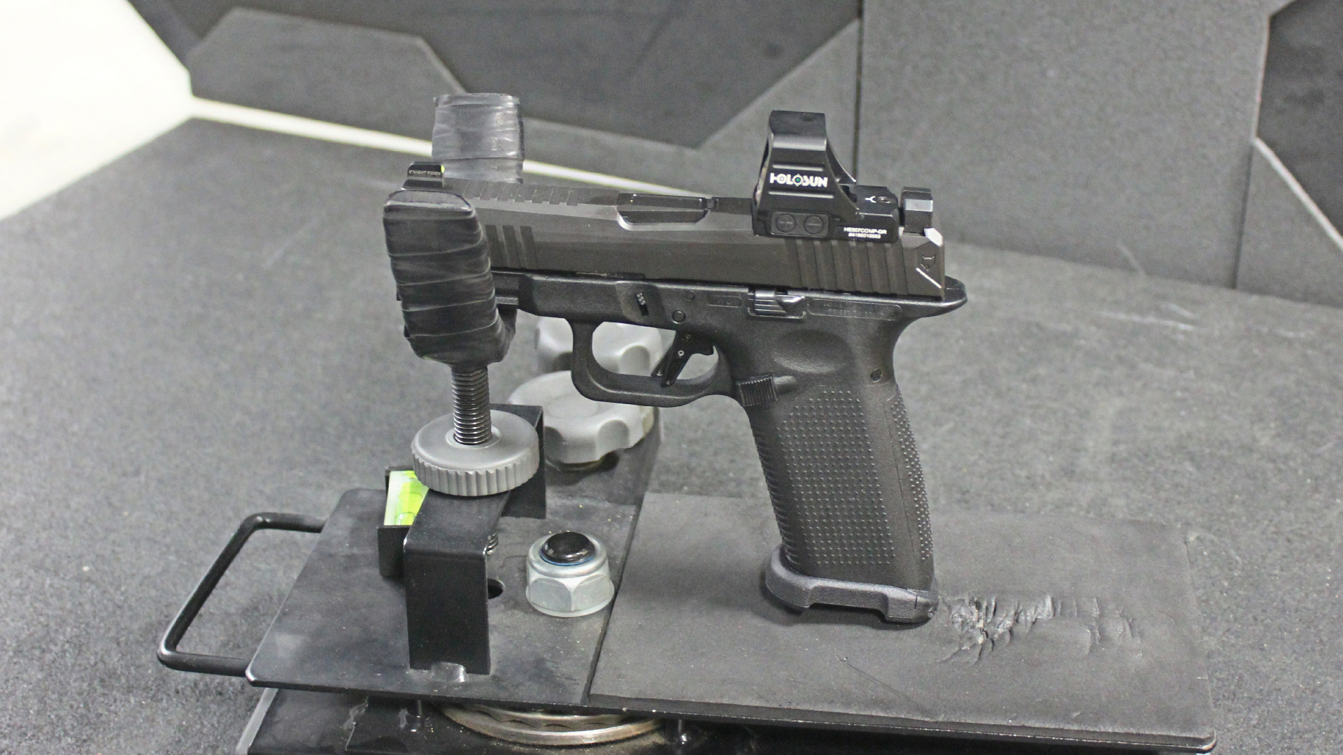 Left-side view of Lone Wolf Timberwolf 19X 9 mm pistol in cradle on range indoors shown with holosun red-dot optic