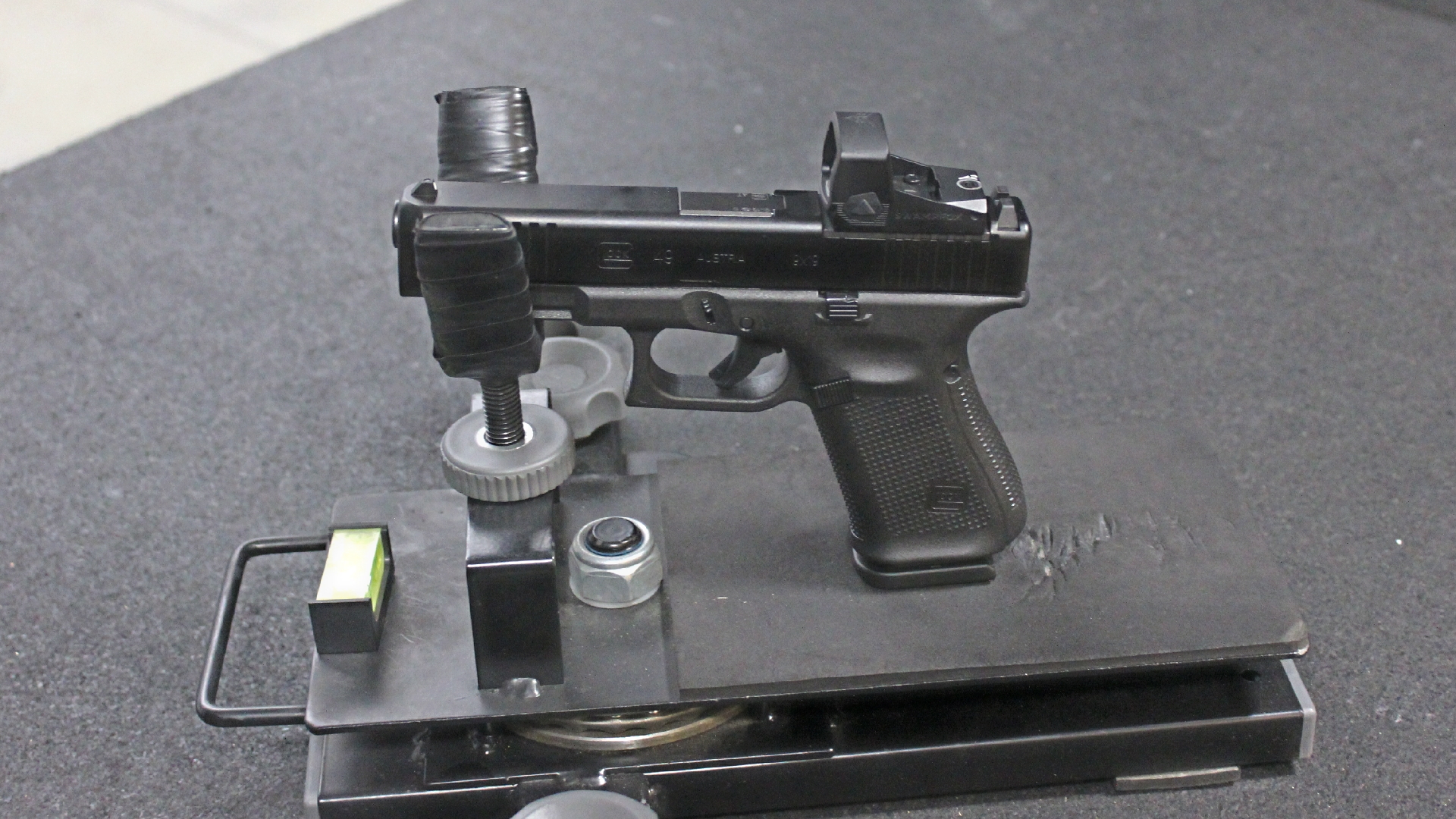 Glock G49 Gen5 MOS shown with Swampfox optic in handgun rest at shooting range