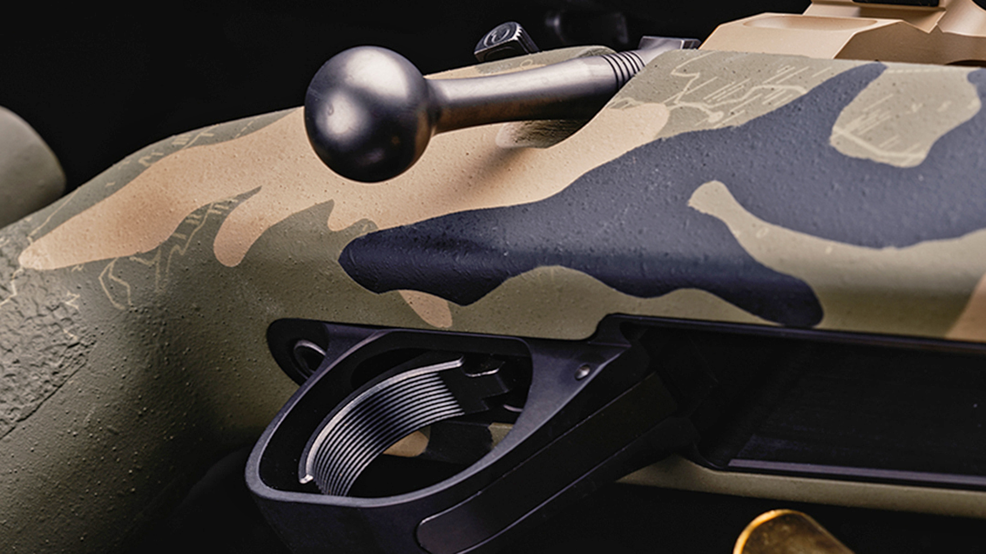 Serrated, black trigger and smooth bolt knob of the Watchtower Bridger bolt-action rifle.