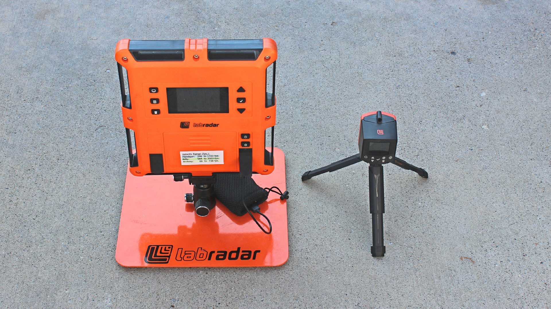 Labradar chronographs side-by-side comparison of old on left square orange machine right small black tripod device