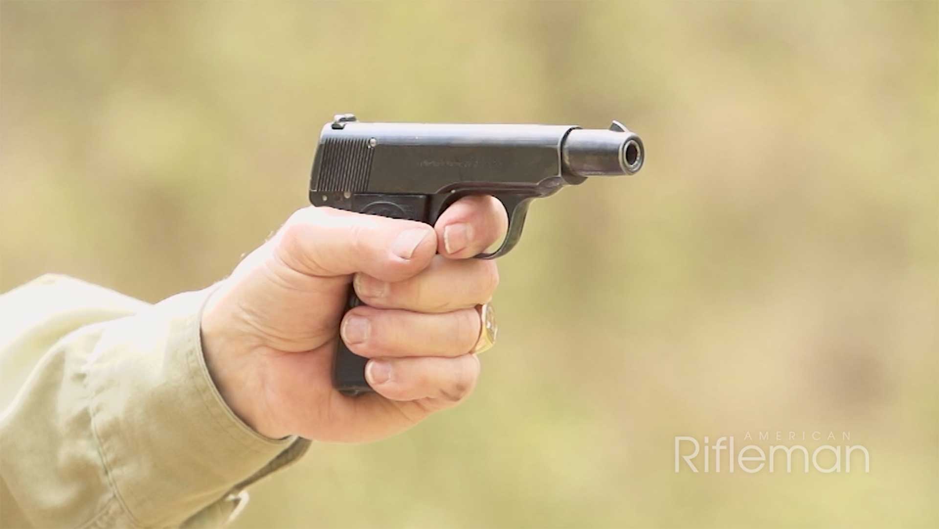 Man shooting the Walther Arms Model 4 on an outdoor range.