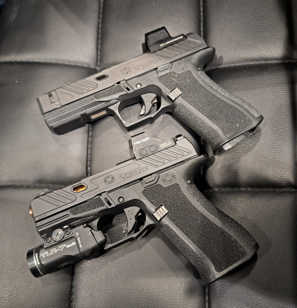 Shadow Systems CR920X and CR920XP pistols left-side view shown on padded black leather weaponlight flashlight accessory red-dot optic