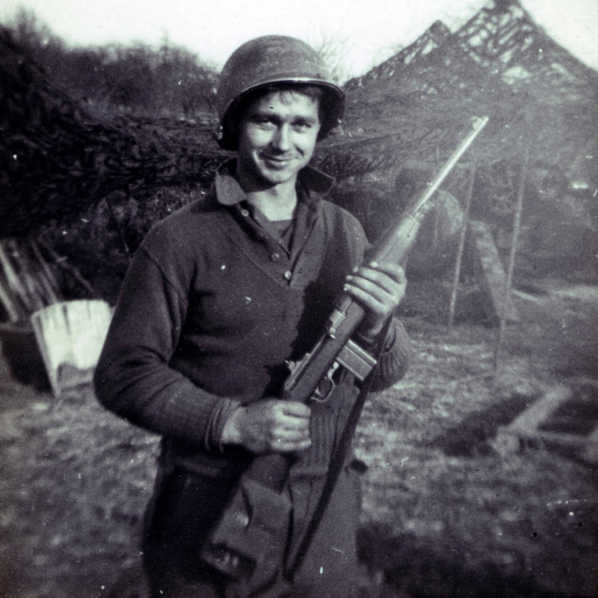 A United States Artilleryman in World War II poses with his M1 carbine at the front.