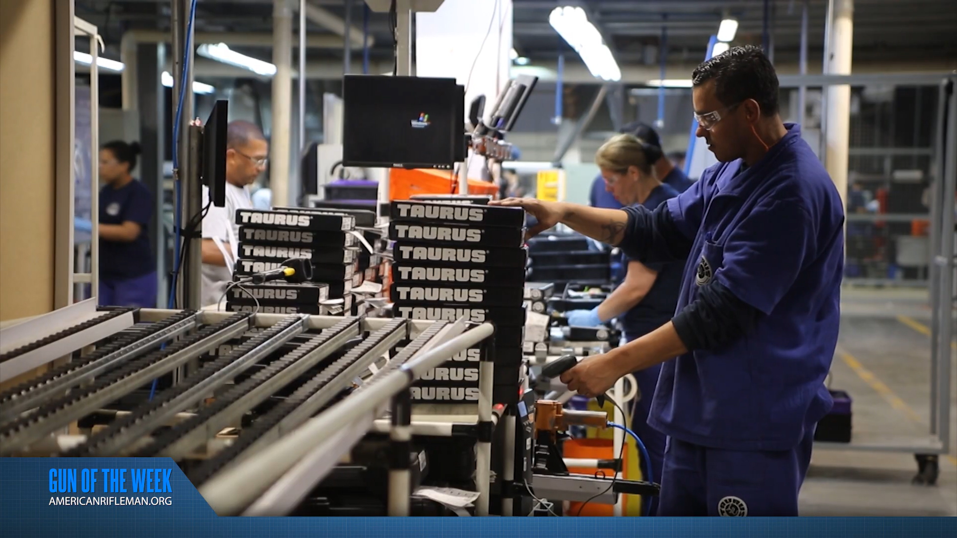 GUN OF THE WEEK text on banner below inside of taurus factory workers blue uniforms boxes of guns conveyour