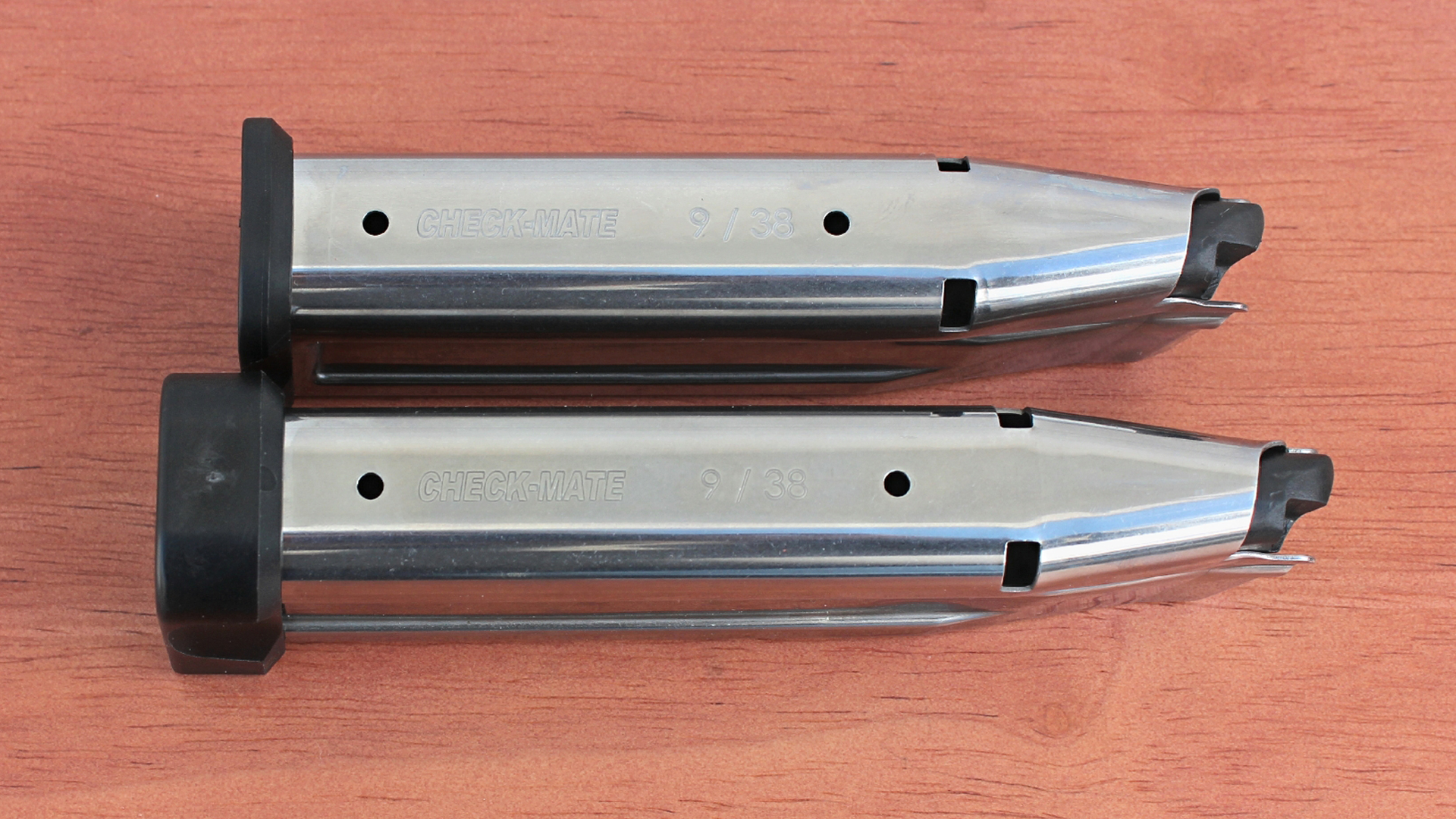 Two Checkmate stainless steel 9 mm double-stack magazines for EAA Corp Girsan Witness2311S Match 9 mm pistol shown on wood table.