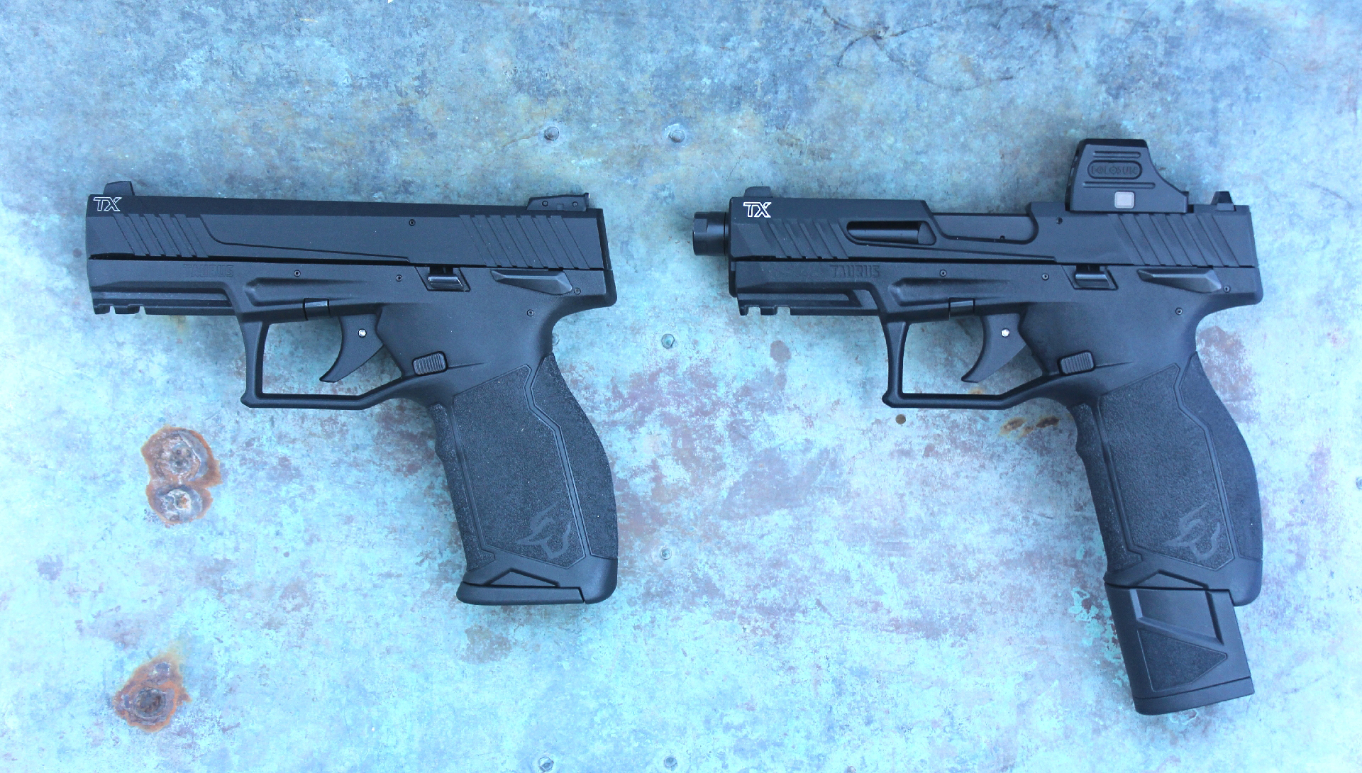 Two Taurus TX22 T.O.R.O. pistols left-side view comparison one with optic and extended magazine shown on rusty steel plate