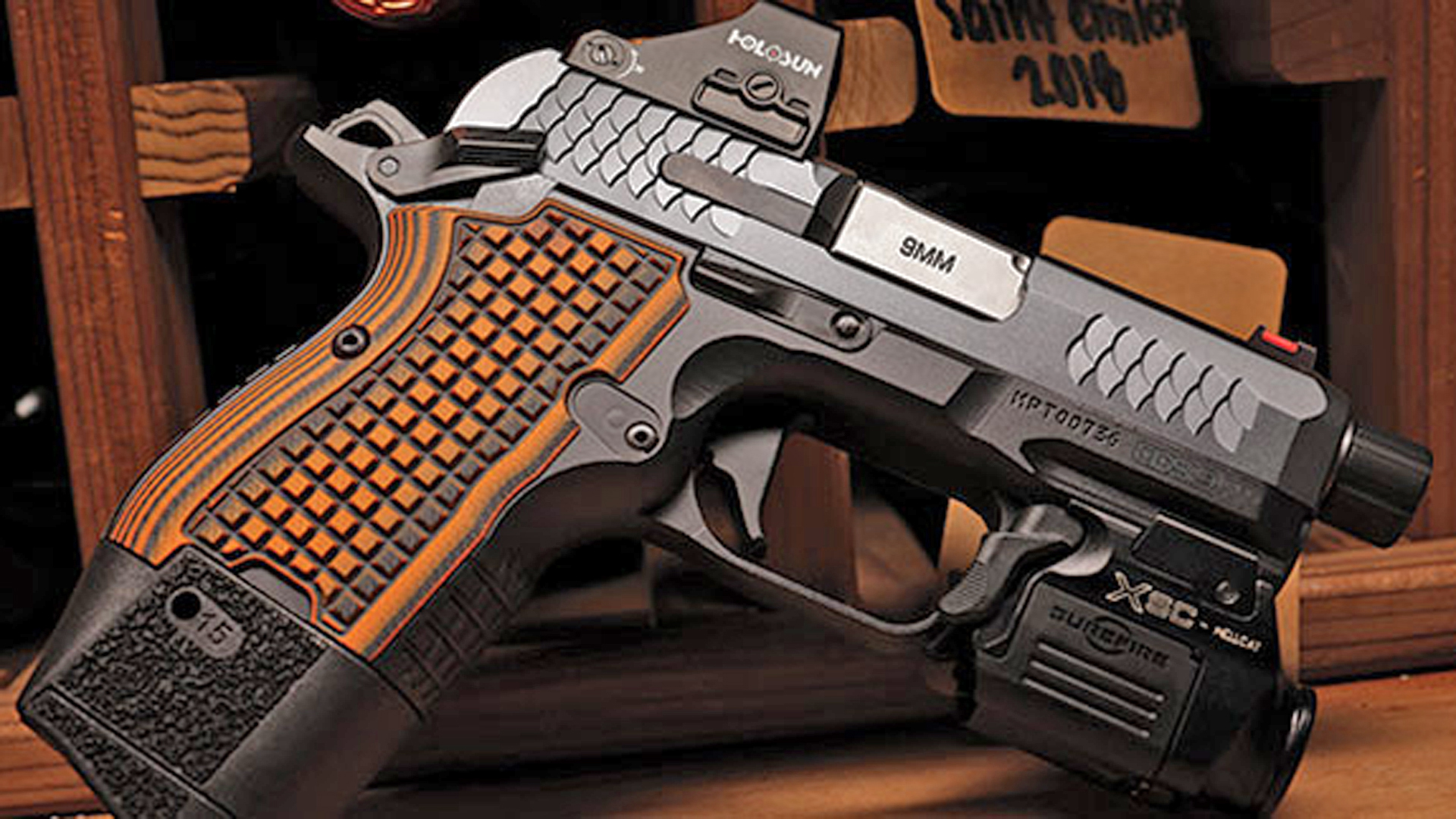 A Kimber CDS9 shown with a Holosun red-dot optic, an attached weaponlight and an extended 15-round magazine.