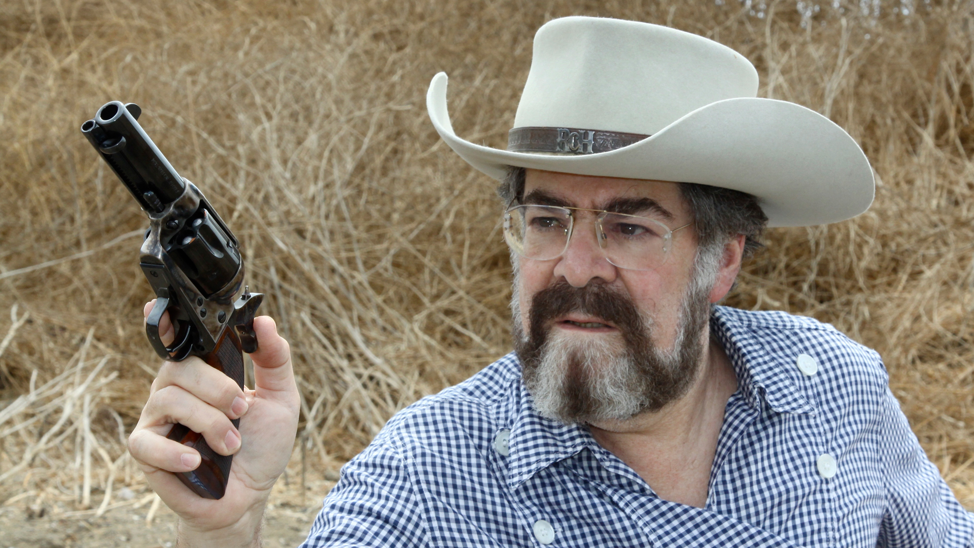 Author Rick Hacker in the field with cowboy hat and single-action revolver in hand