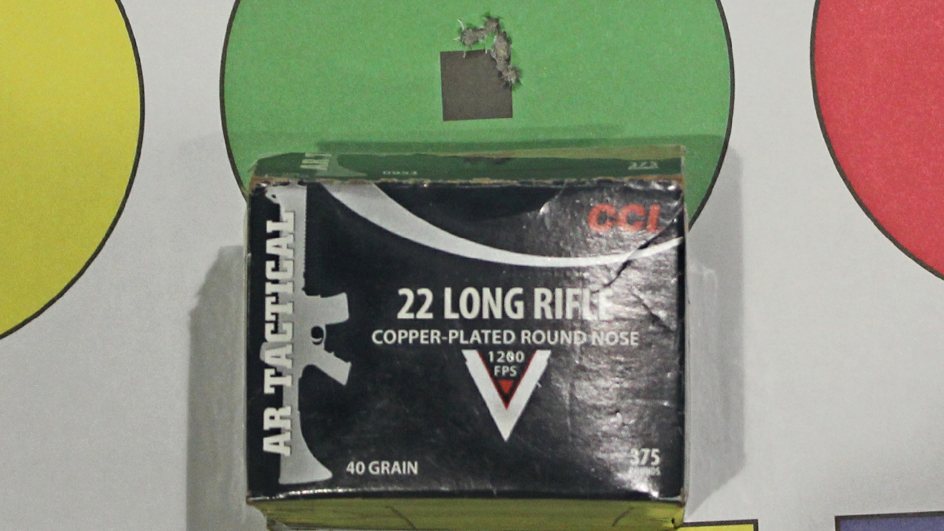 CCI 22 long rifle ammunition box next to circular target bullet holes accuracy tippmann m4-22 lte