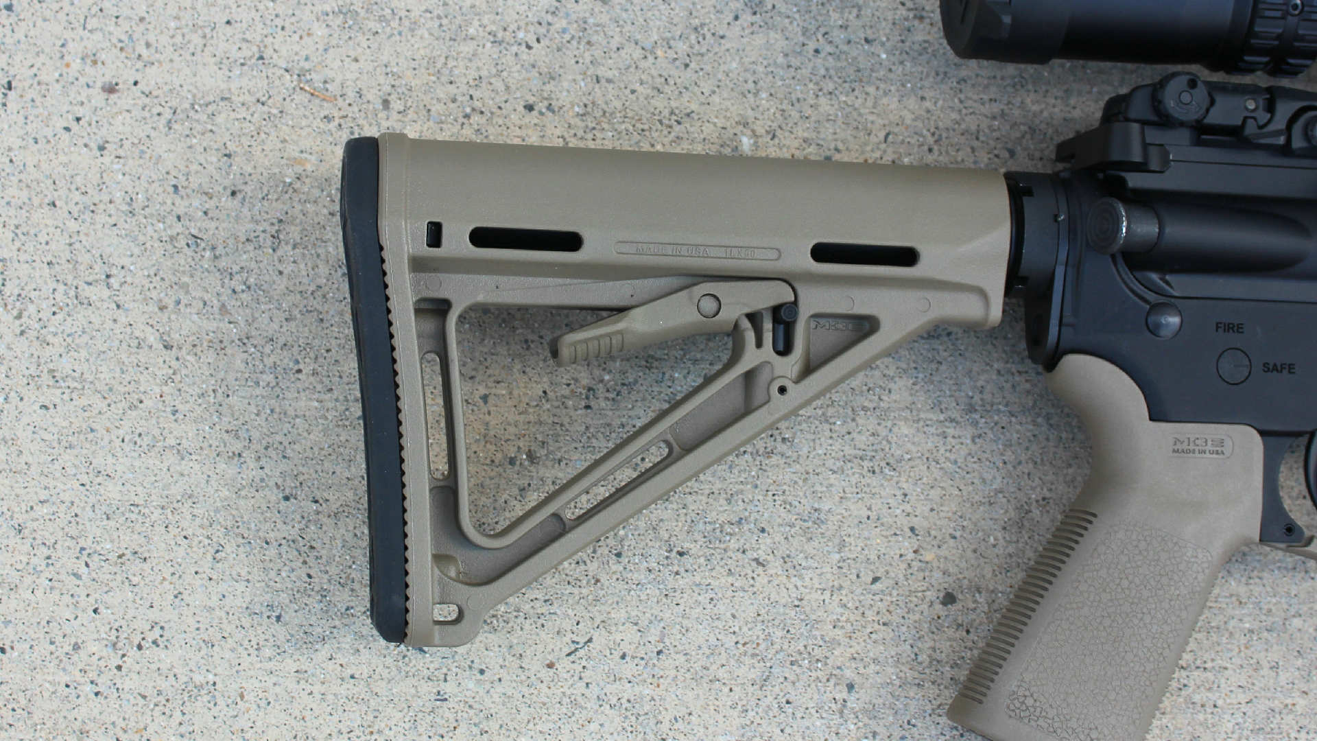 Magpul MOE stock adjustable FDE color attached to PSA PA-15 carbine right-side view on concrete floor