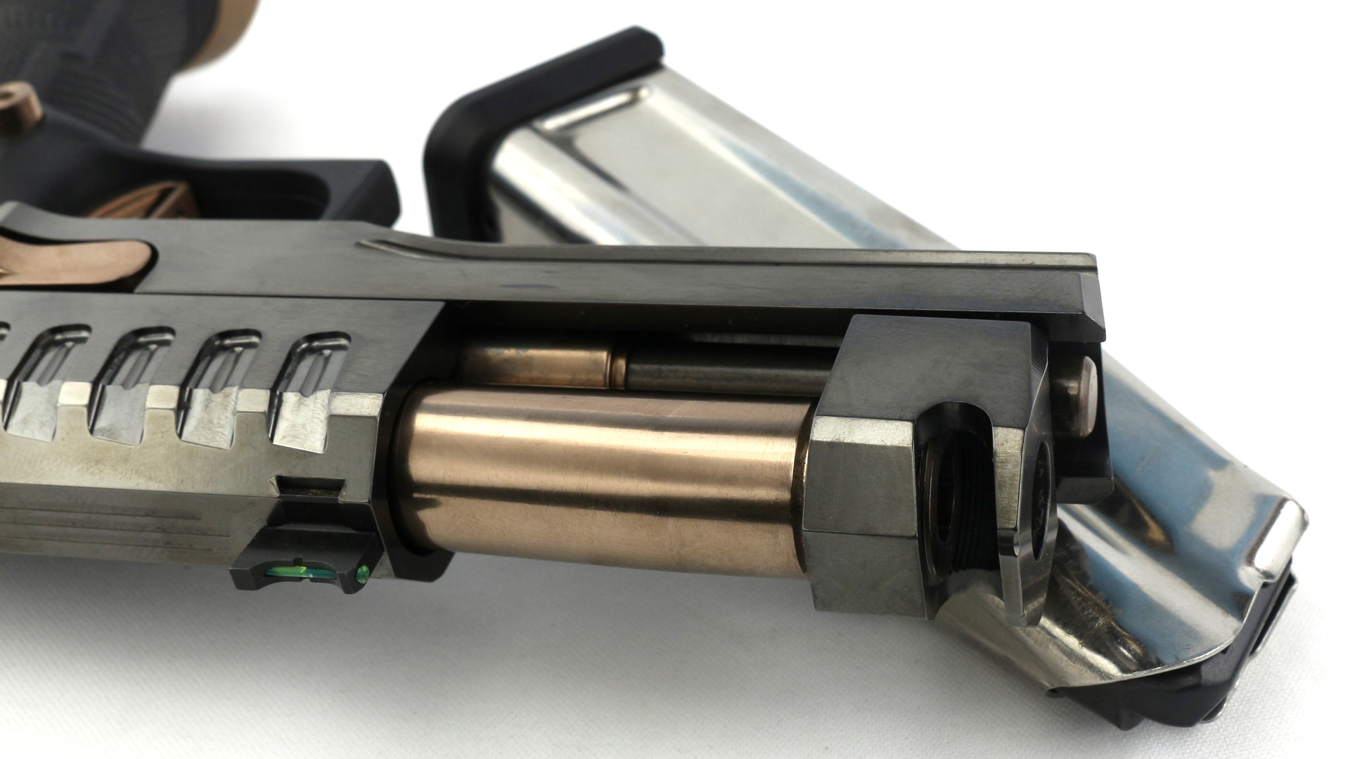 Watchtower Firearms Apache pistol double-stack m1911 closeup of slide locked rear and barrel compensator shown with empty silver stainless steel magazine