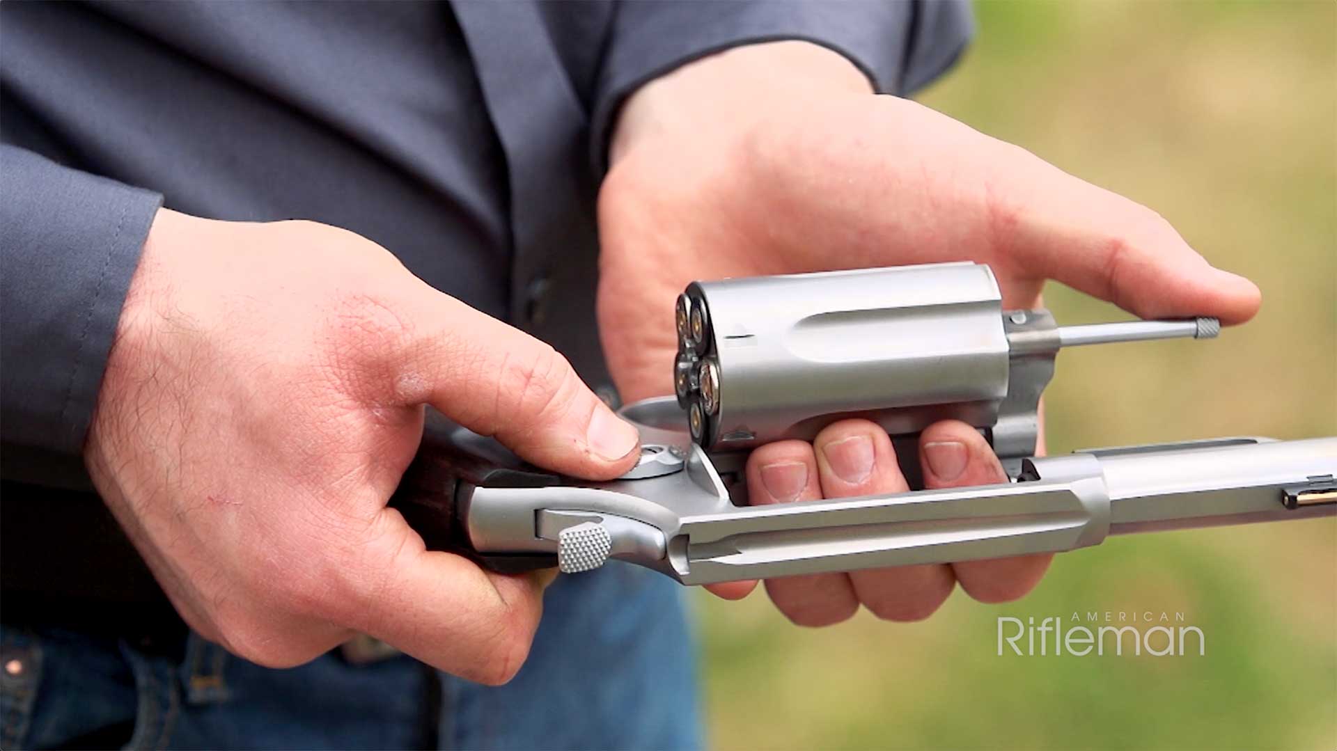 A man removing the cylinder from the Taurus Judge Executive Grade's frame.