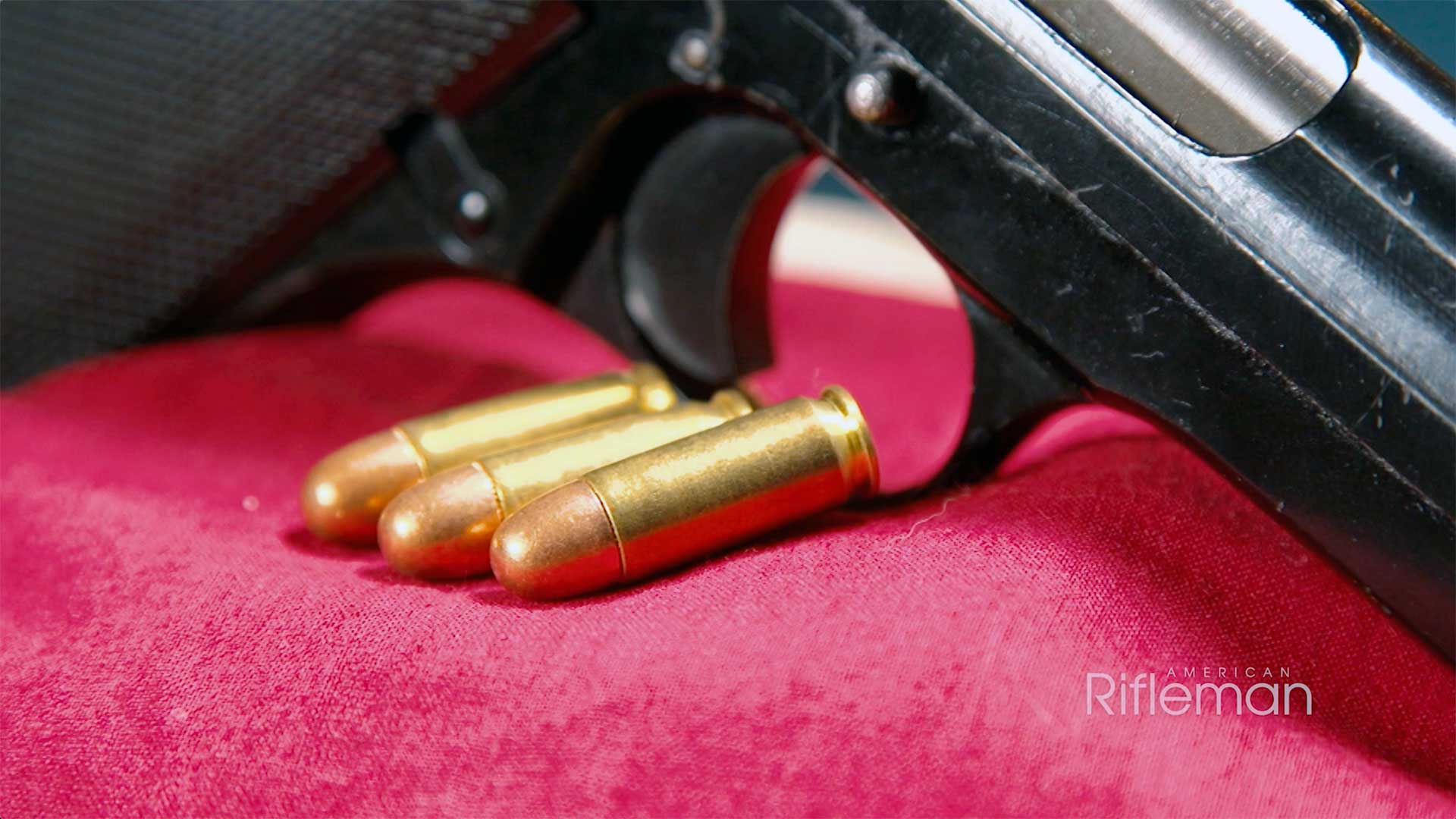 Three rounds of 7.65 French Long ammunition on a piece of red cloth.