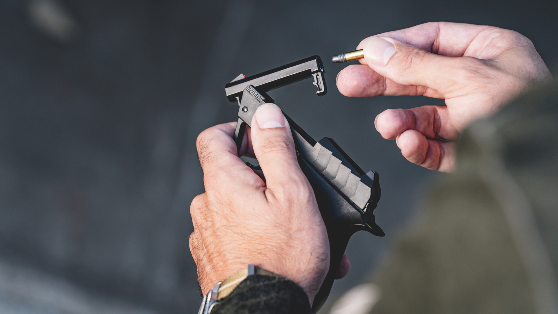 Man loading a Taurus 22TUC through the tip-up barrel.