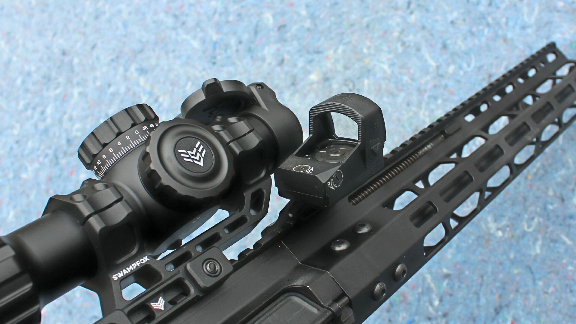 Review: Global Ordnance Monolith accessory mounts optics swamp fox rebel offset shown with lpvo on blue background