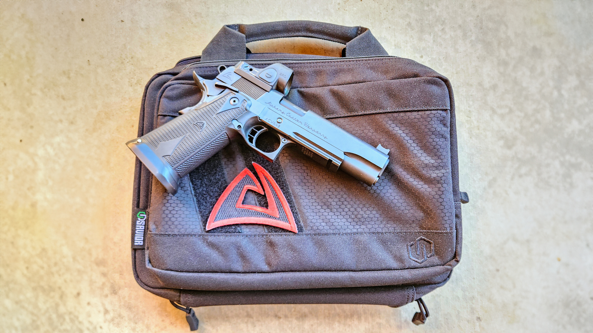 Alchemy Custom Weaponry Quantico HiCap pistol right-side view shown on Savior pistol handgun bag on concrete floor