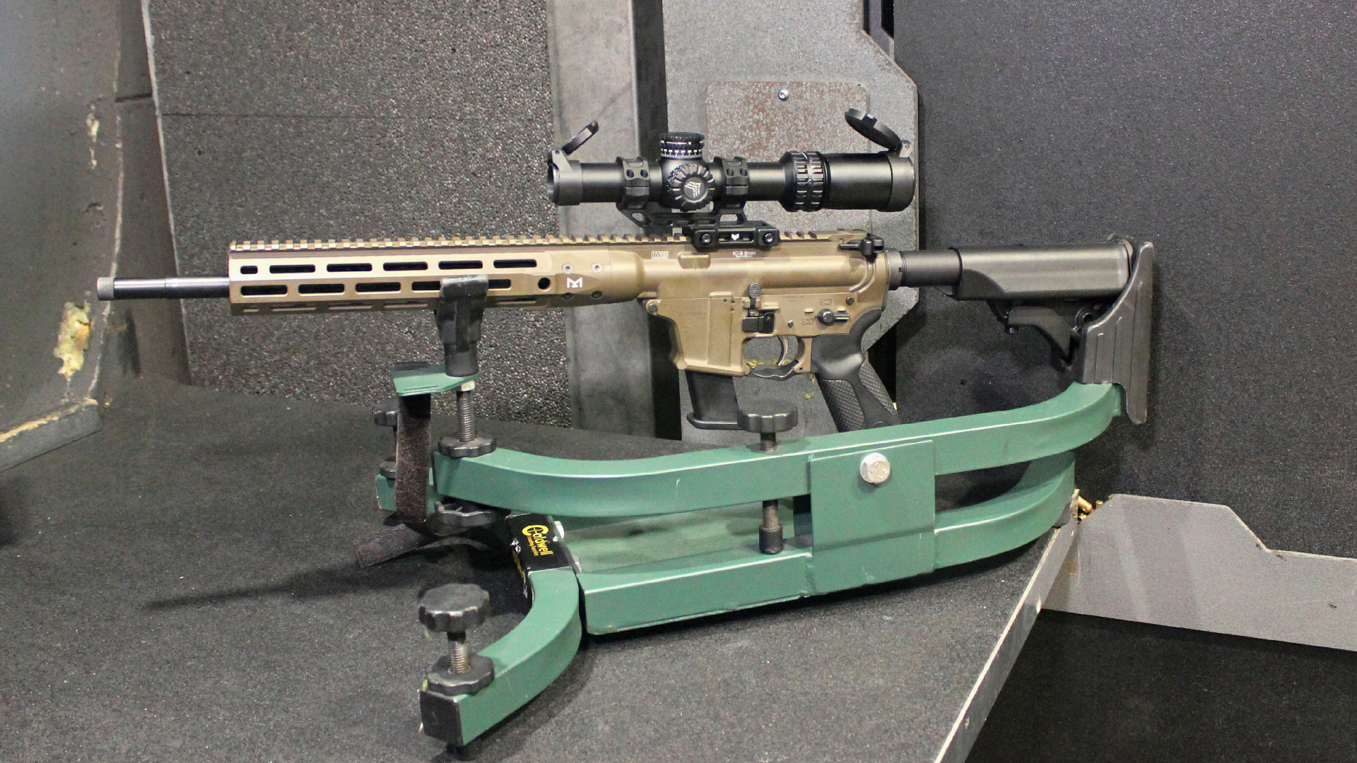 Left-side view of LWRCI IC 9 Carbine in rifle rest indoors dark shooting range bench booth