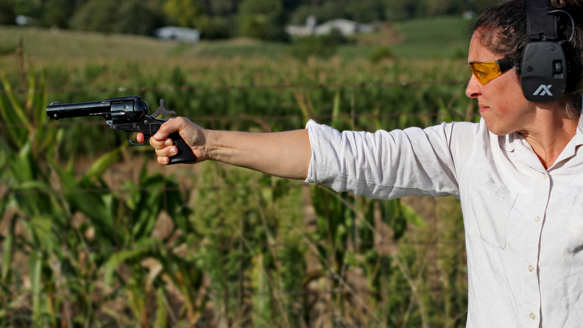 Woman outdoors holding taurus deputy revolver arm outstretched