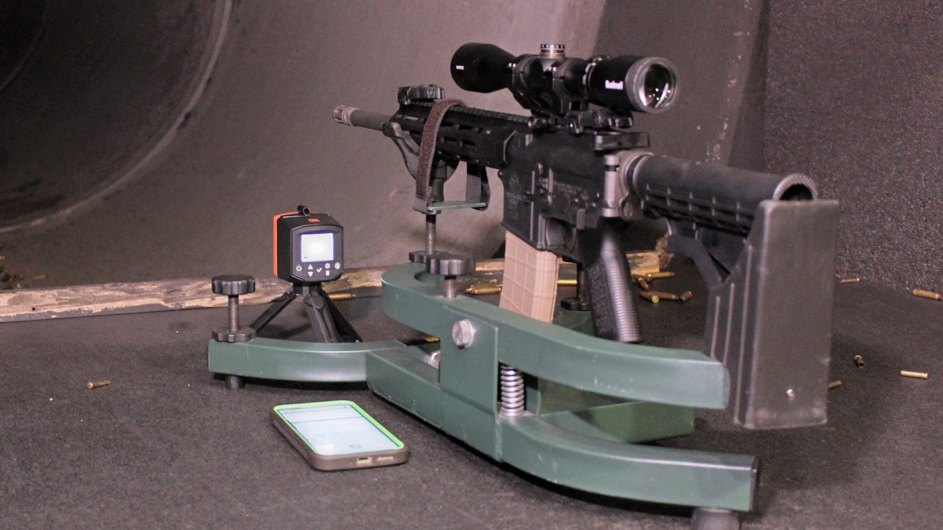 Labradar LX chronograph on shooting bench next to rifle in rest dark tunnel range