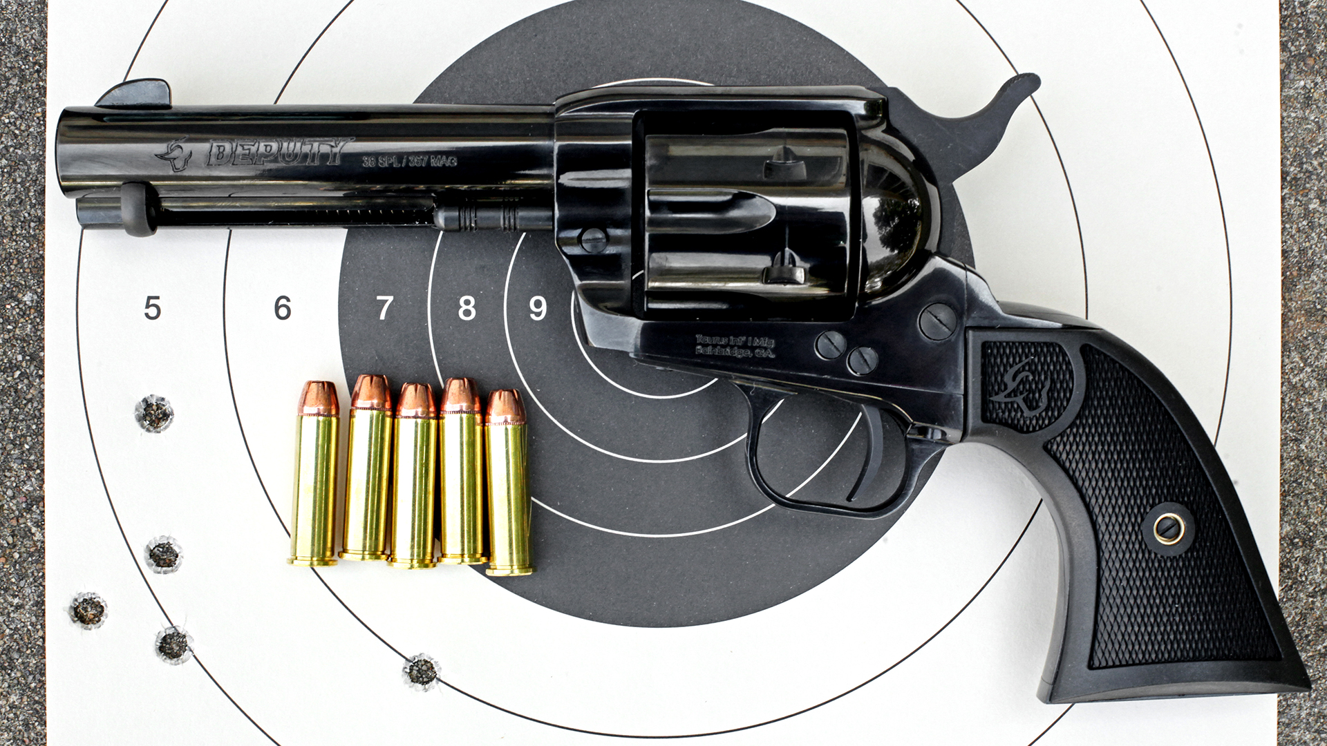 Taurus Deputy single-action revolver shown on bullseye target with ammunition left-side view