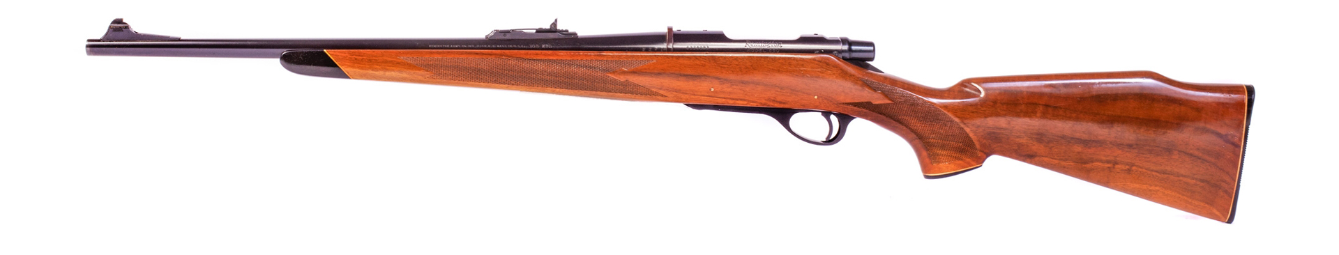 Remington Model 660 bolt-action rifle left-side view on white wood stock gun