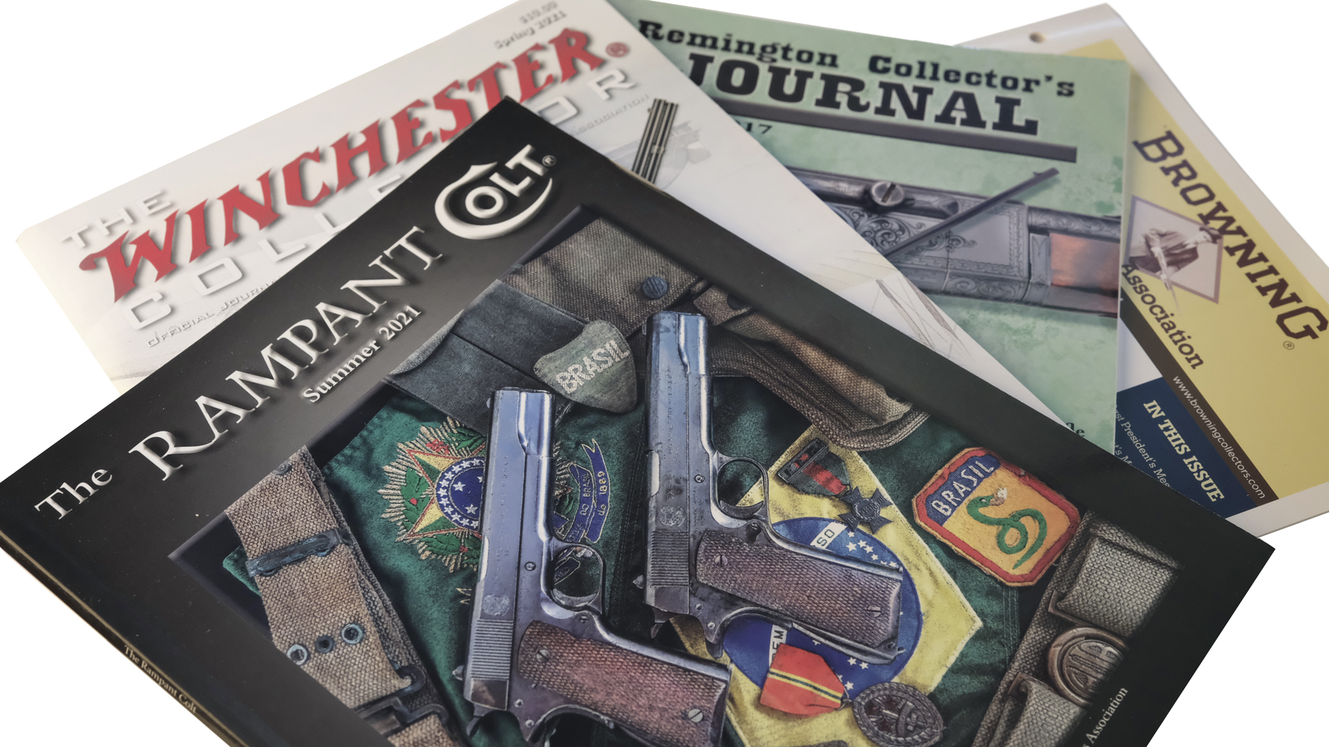 Firearm manufacturer catalogs and collector journals fanned out four magazines Colt Winchester Remington Browning