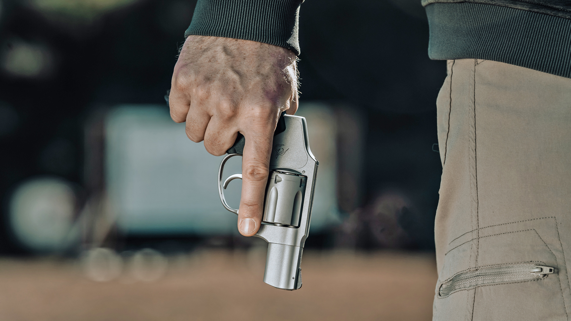 A man holding the Taurus 850 revolver in an urban setting.