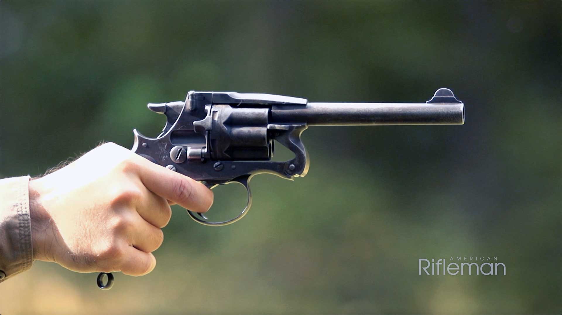 A hand aiming an Enfield Mk II revolver downrange.
