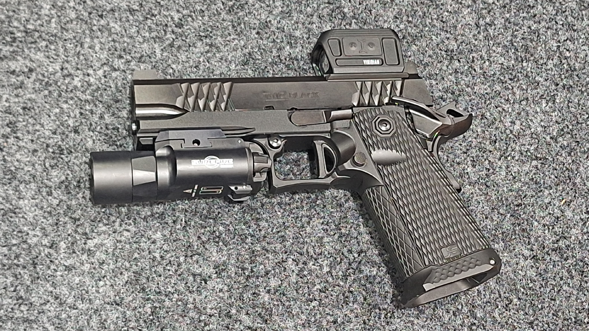 Jacob Grey TWC Black 2011 double-stack 9mm pistol left-side view on carpet shown with weaponlight flashlight