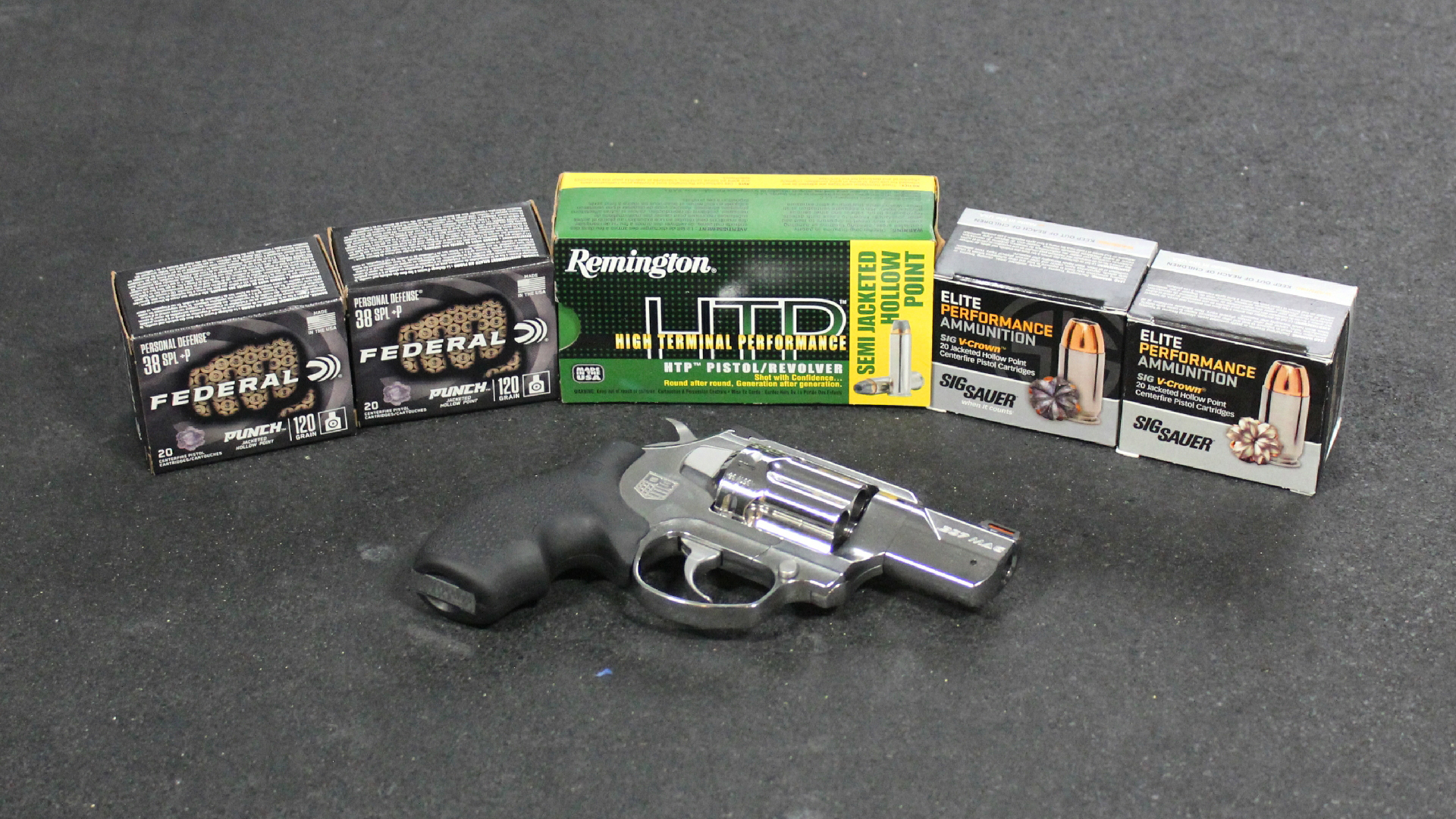 Diamondback Firearms SDR stainless steel revolver center surrouneded by five boxes of ammunition