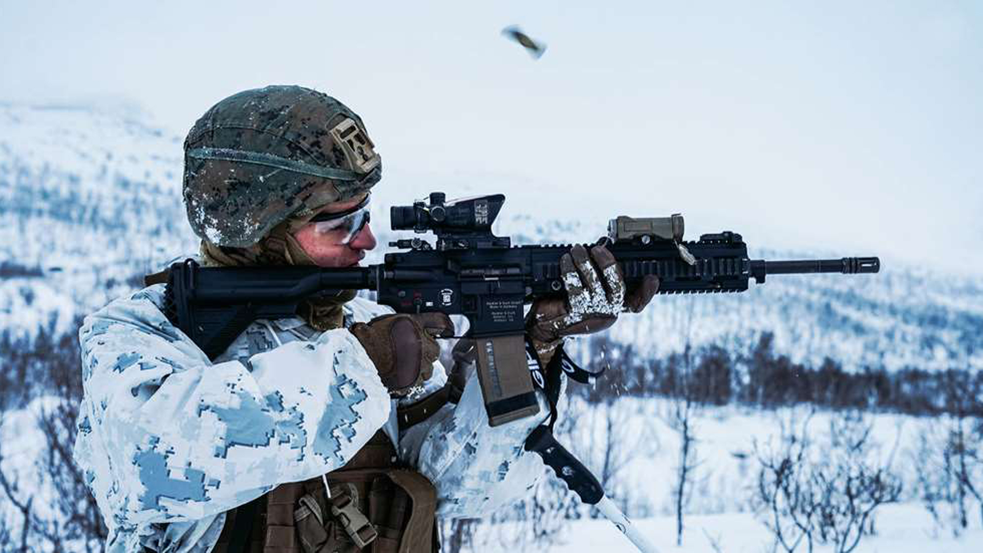 Man in arctic camouflage shooting the HK MR556 A4 rifle.