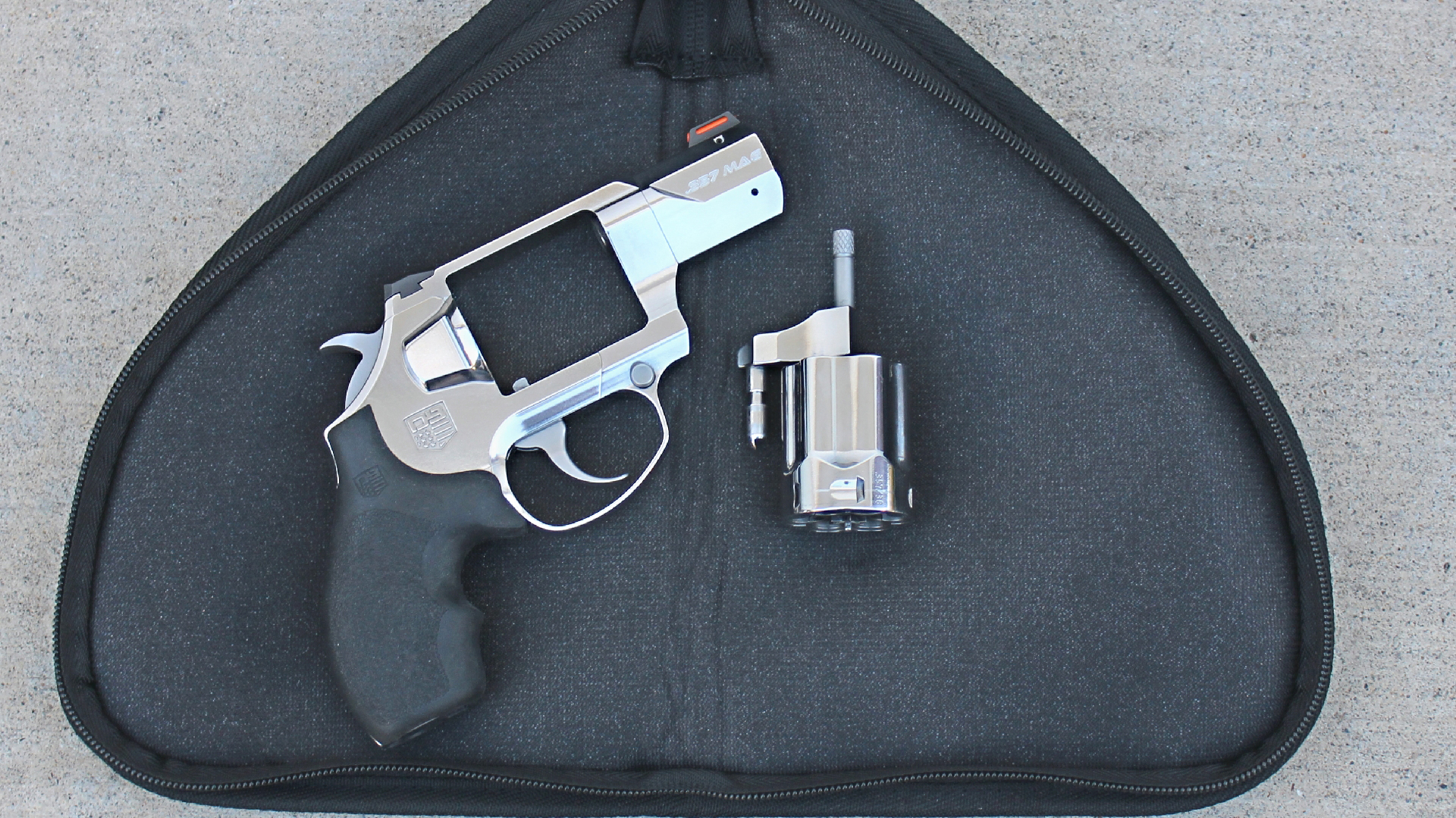 Diamondback Firearms revolver right-side view on zippered black case shown with stainless steel cylinder removed and resting right of gun frame