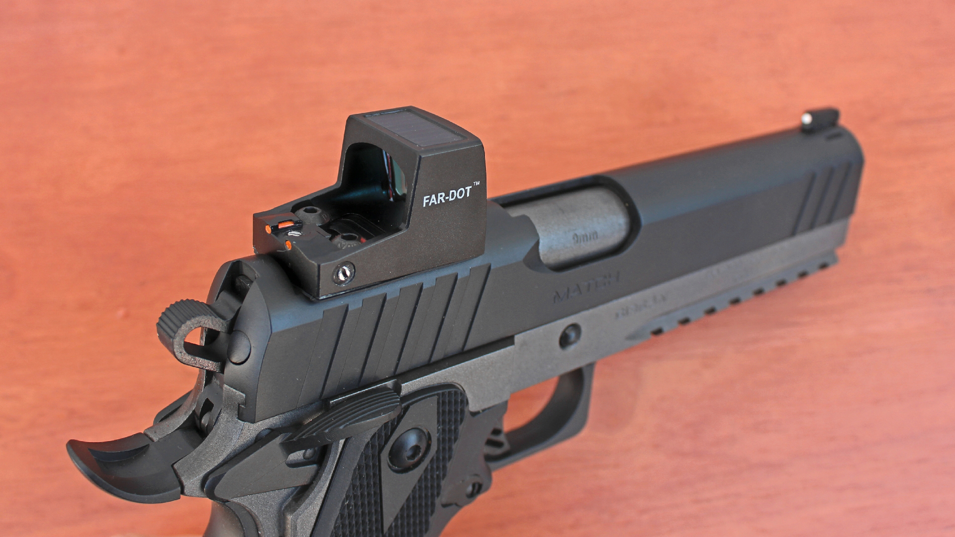 EAA Corp Girsan Witness2311S Match pistol top-down view illustrating FAR-DOT optic attached to top of black slide. Wood background.