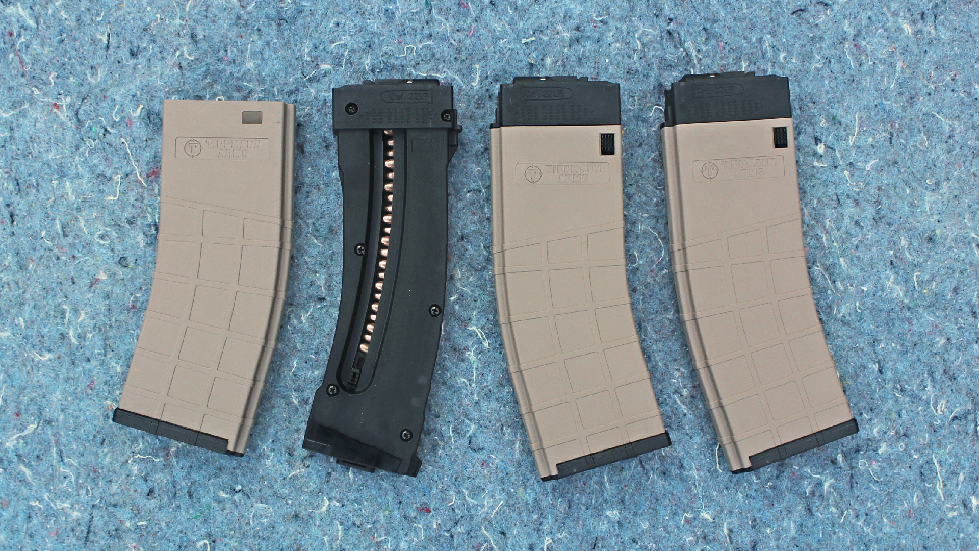 .22 Long Rifle magazines side-by-side comparison gun parts on blue floor