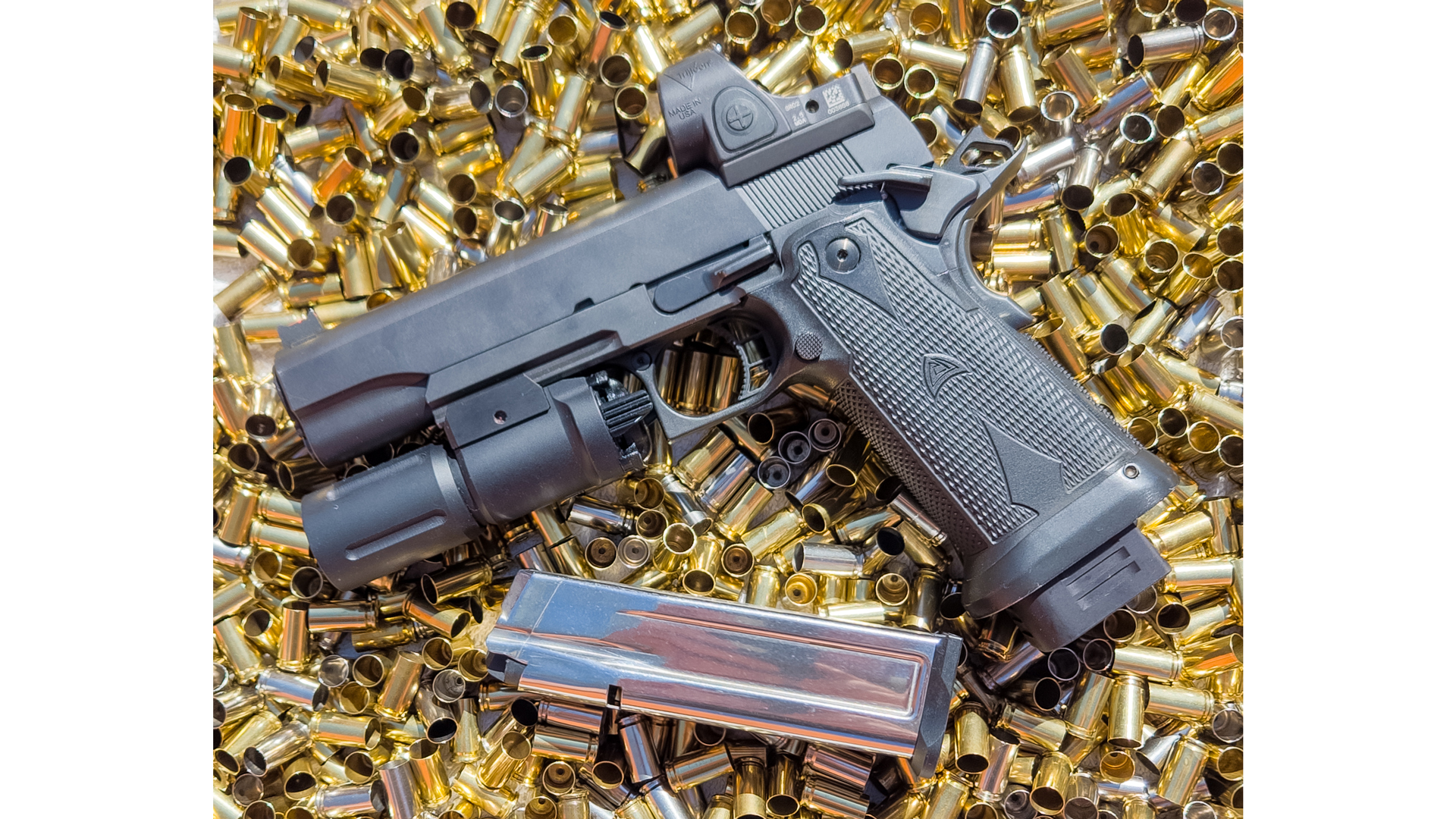 Alchemy Custom Weaponry Quantico HiCap pistol left-side view on empty brass cases