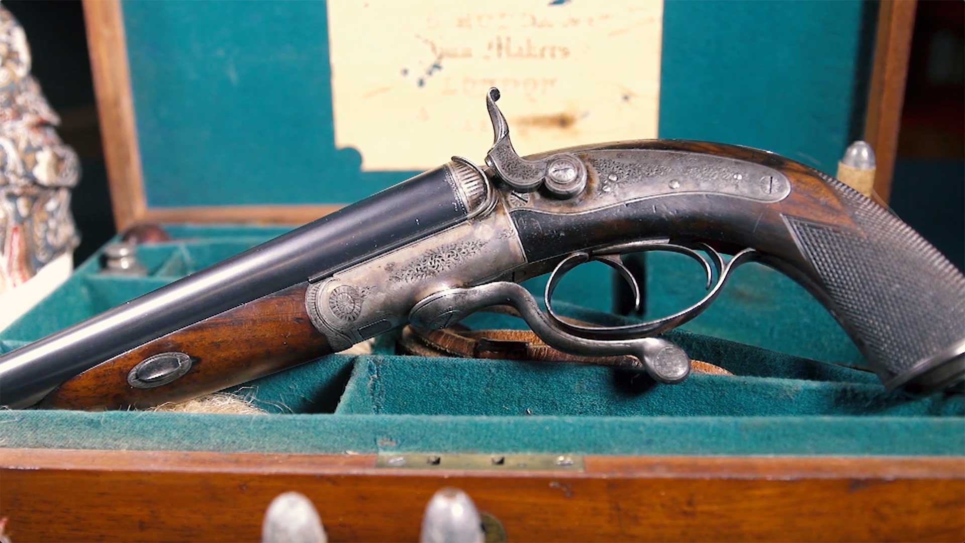 Left side of a British-made Howdah pistol sitting inside of a velvet-lined case.