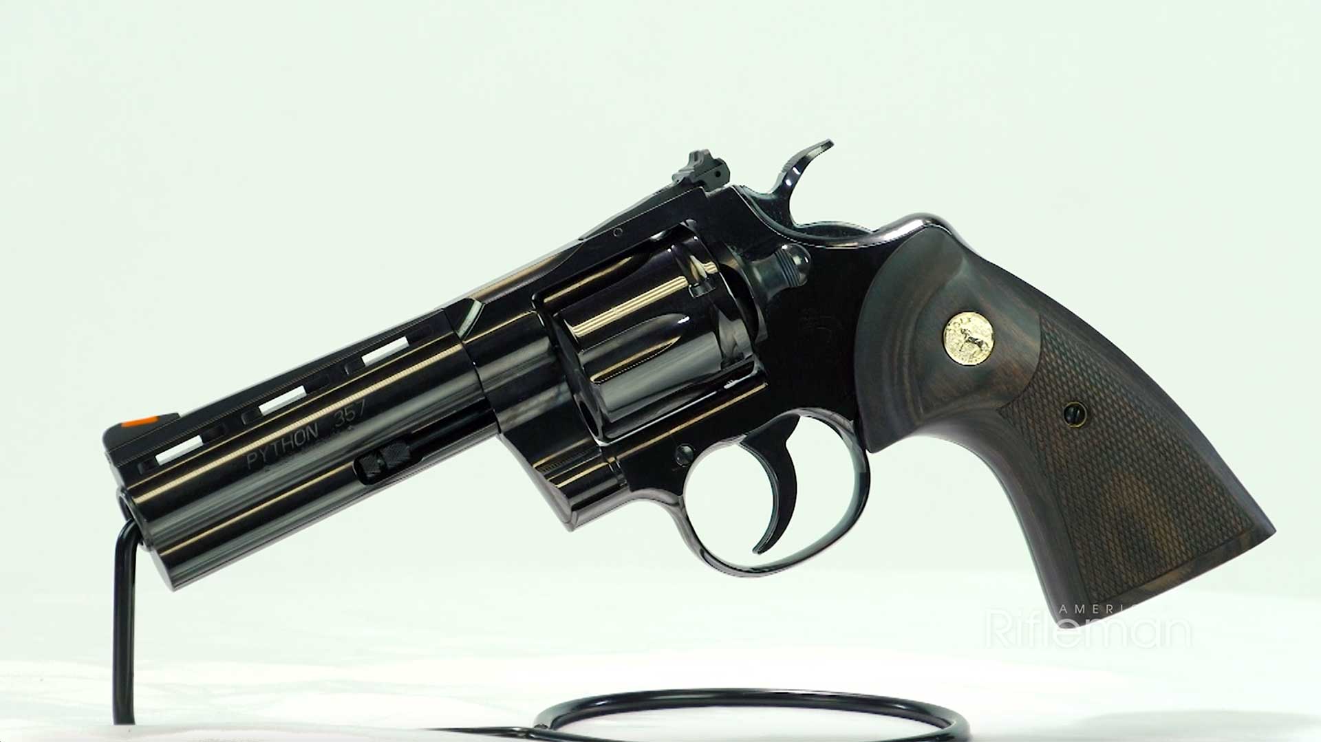 Colt Blued Python left-side view on wire stand shown with walnut target grips and gold medallion