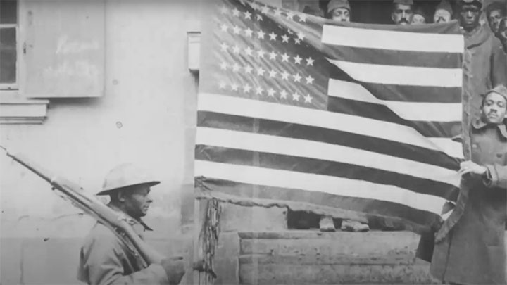 African American soldiers posing with the American flag.
