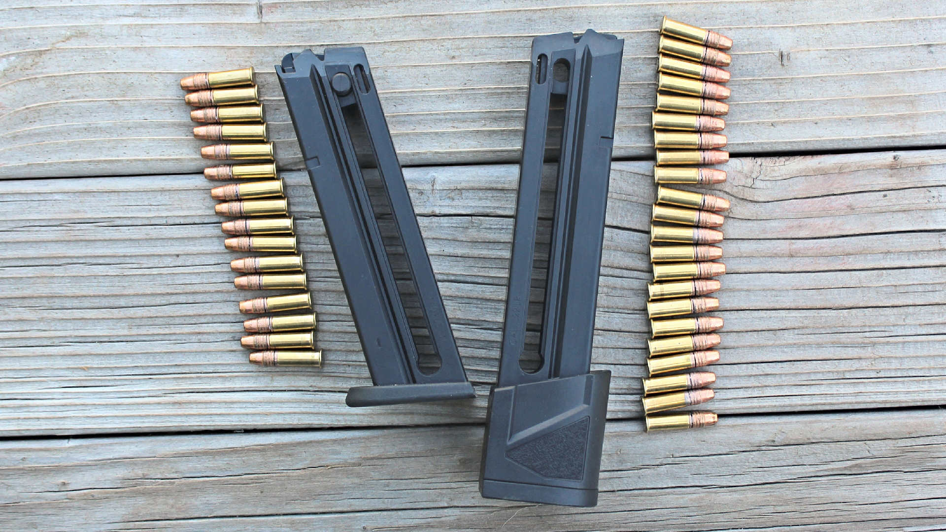 Taurus TX22 black magazine comparison shown with ammunition on wood background