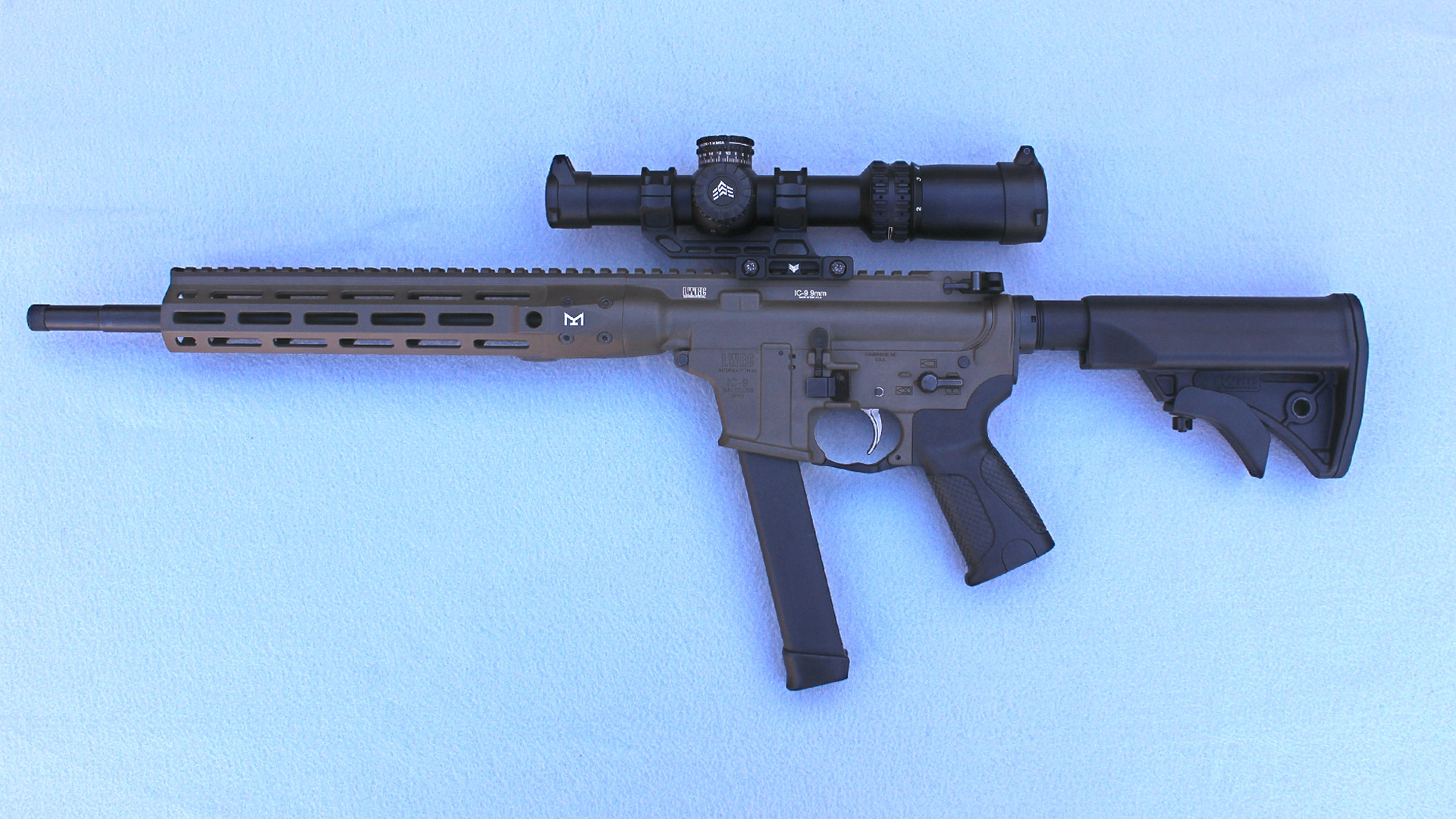 LWRCI IC 9 Carbine left-side full-length shown with magazine and riflescope blue background