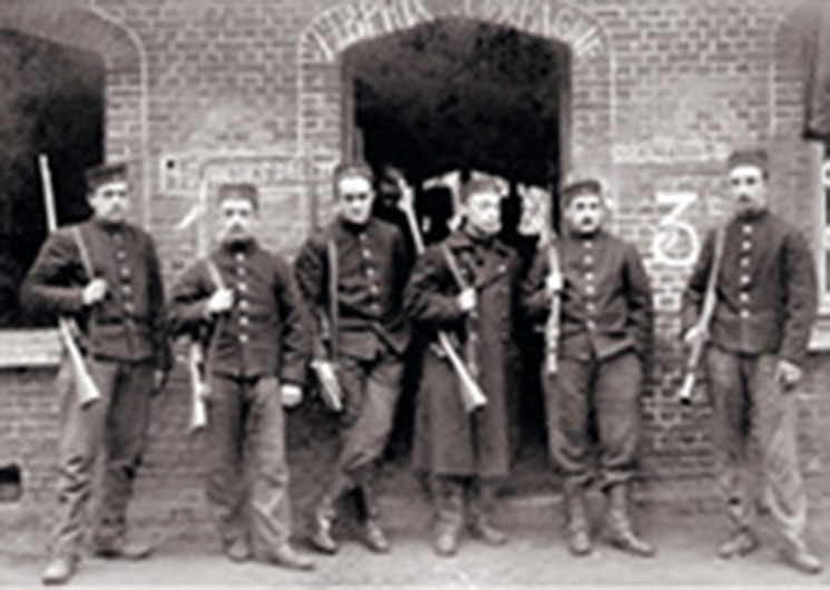 soldiers in front of brick wall with belgian mauser rifles