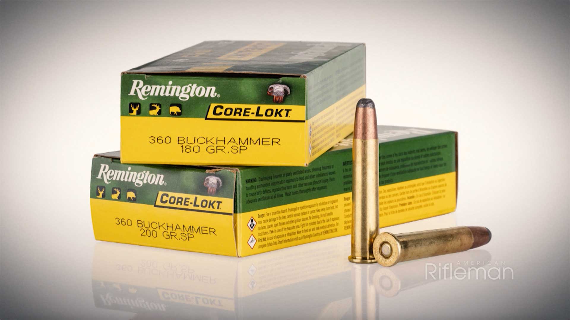 Two stacked yellow and green boxes of Remington Ammunition next to two 360 Buckhammer cartridges.